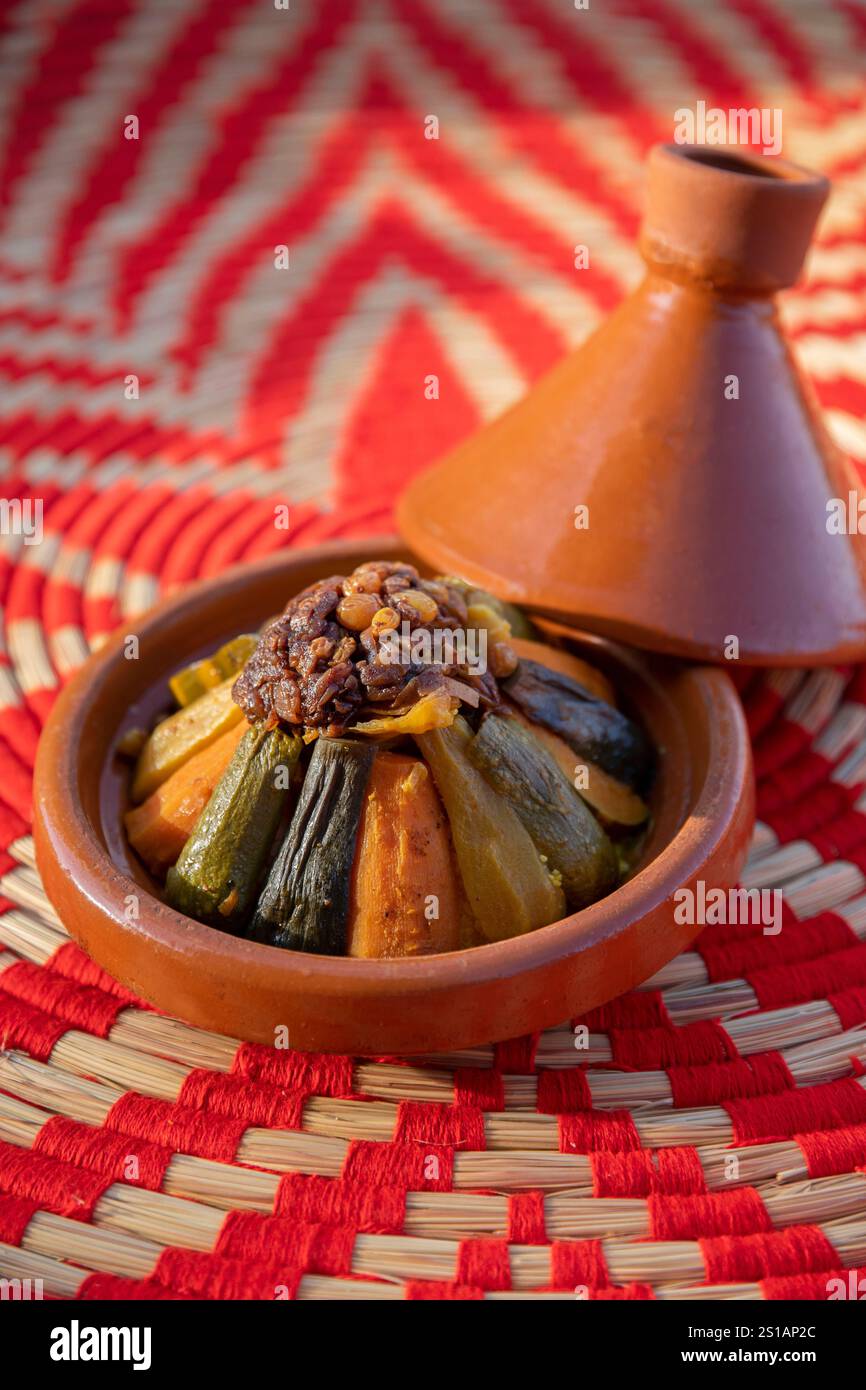 Marokko, Agafay, marokkanische Gemüse-Tagine, serviert in einem Terrakotta-Tagine-Gericht auf einem Gemüsefaseruntersetzer im Anara Camp Hotel Stockfoto