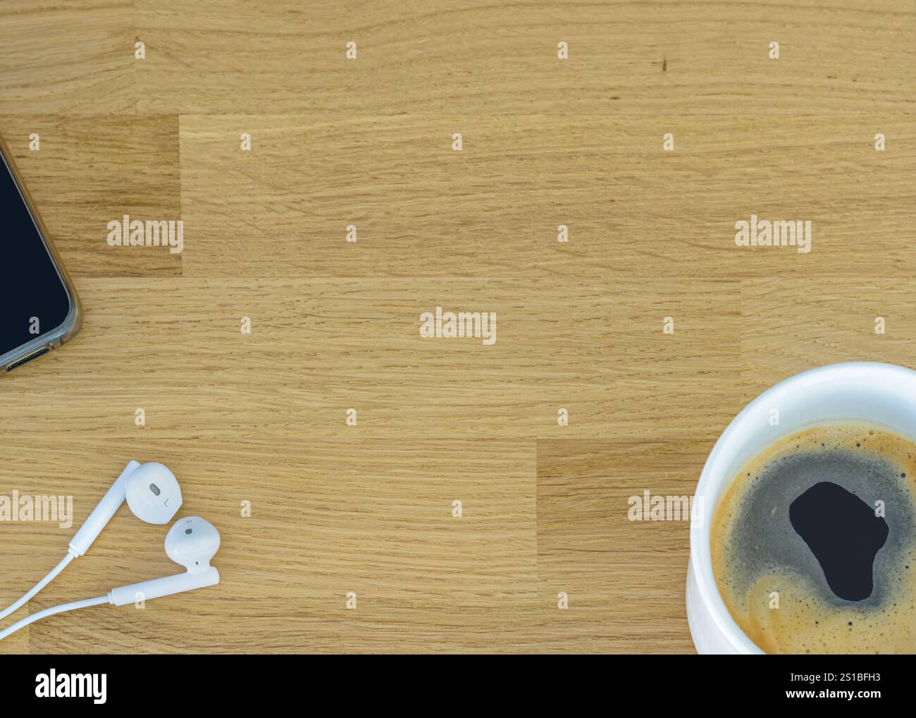 Hölzerner Schreibtisch Hintergrund mit Smartphone, Kopfhörer und Tasse Kaffee. Draufsicht mit Kopierraum, flache Ladefläche. Stockfoto