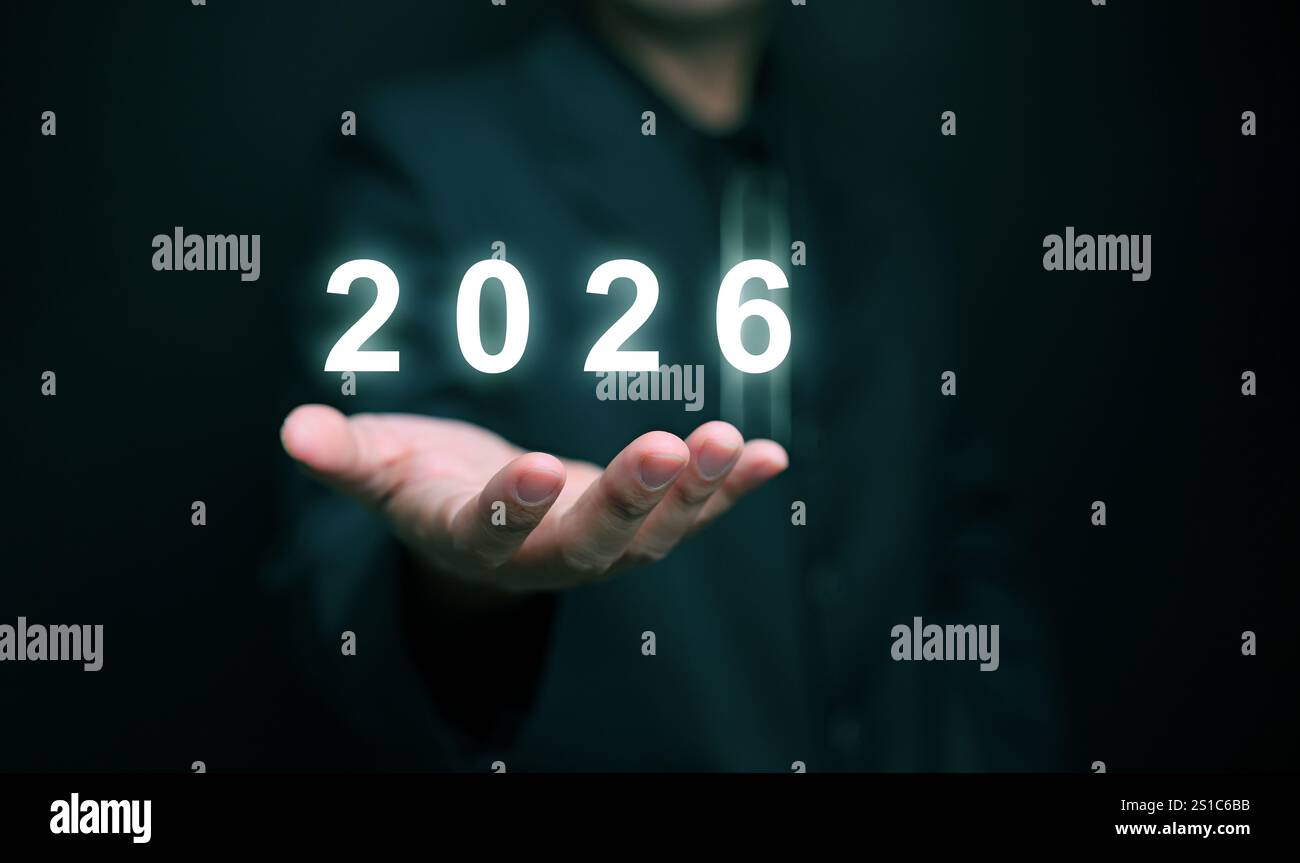 Frohes neues Jahr 2026. Ein Geschäftsmann hält das wechselnde Jahr an der Hand, bereit, 2026 zu beginnen oder zu beginnen. Stockfoto