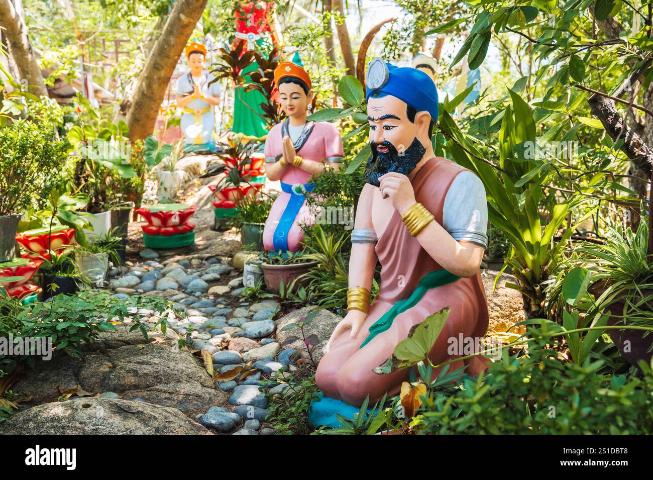 Figuren asiatischer Götter stehen auf der Straße auf dem Territorium eines buddhistischen Tempels. Stockfoto