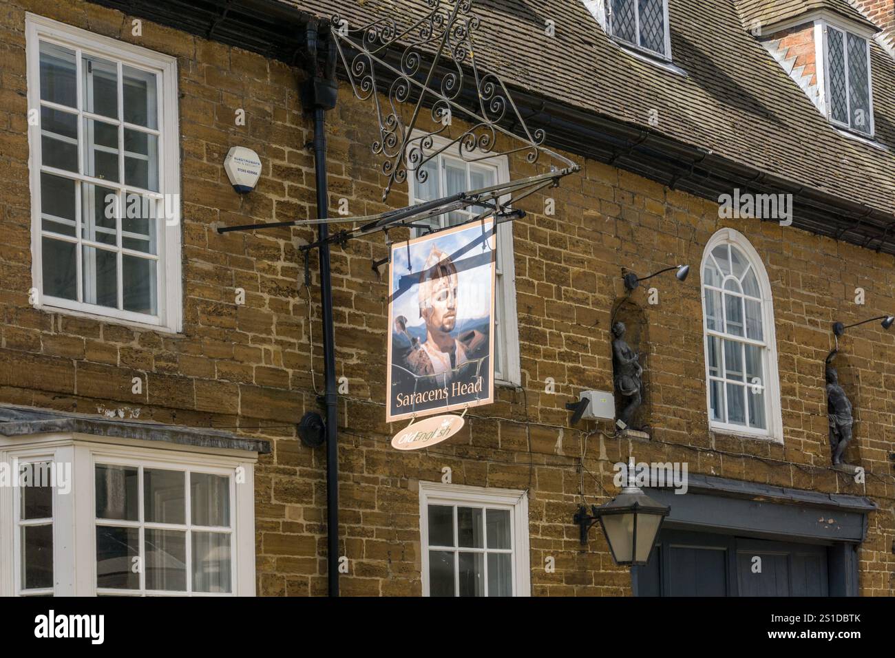 Pub-Schild und Fassade für das Saracens Head, ein Greene King Pub im Stadtzentrum von Towcester, Northamptonshire, Großbritannien Stockfoto