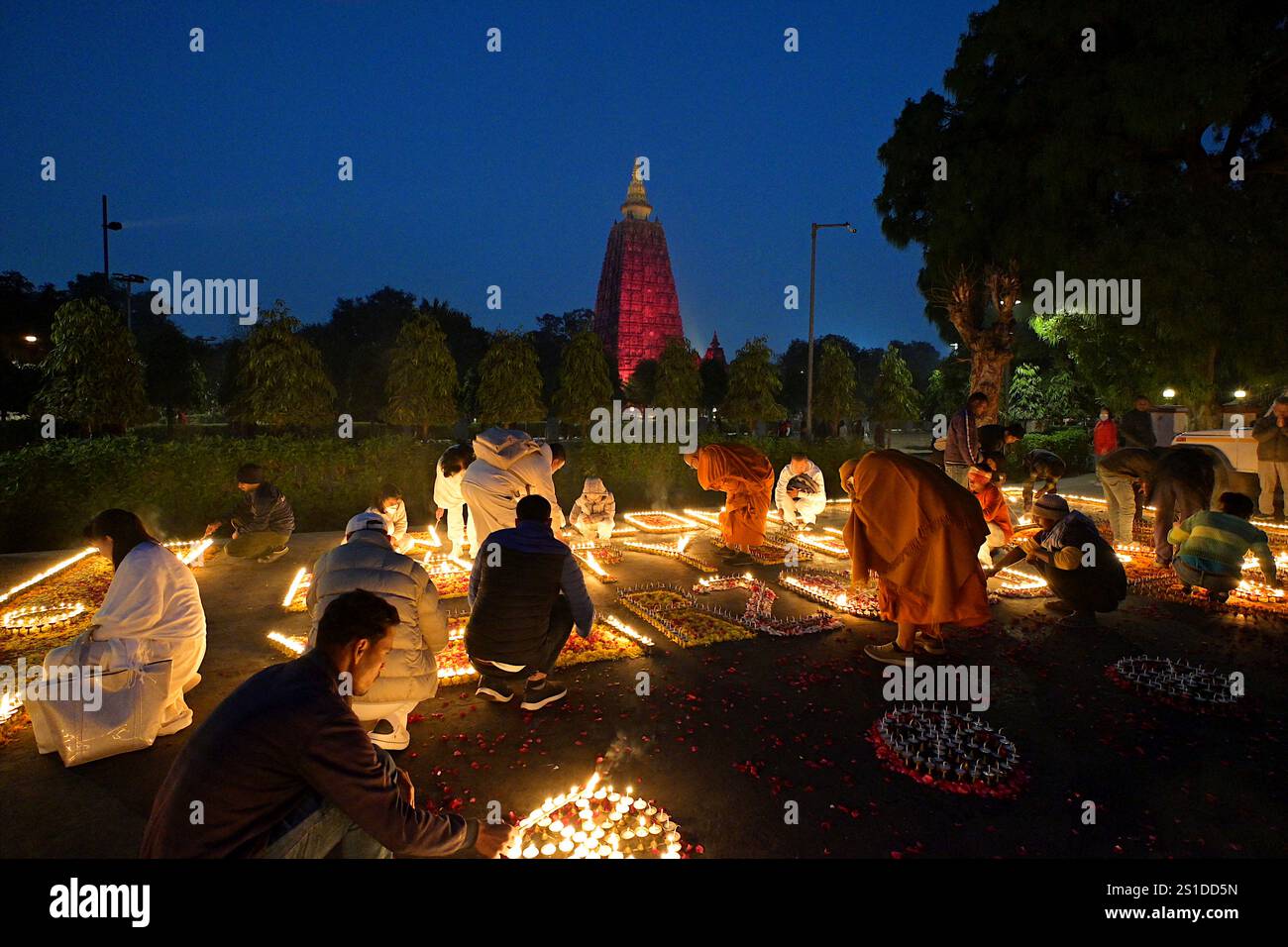 Der Mahabodhi-Tempel leuchtet rot, während die Schwärmer Kerzen im Butter Lamp House zünden, um das neue Jahr 2025 in Bodhgaya, Indien, zu feiern Stockfoto