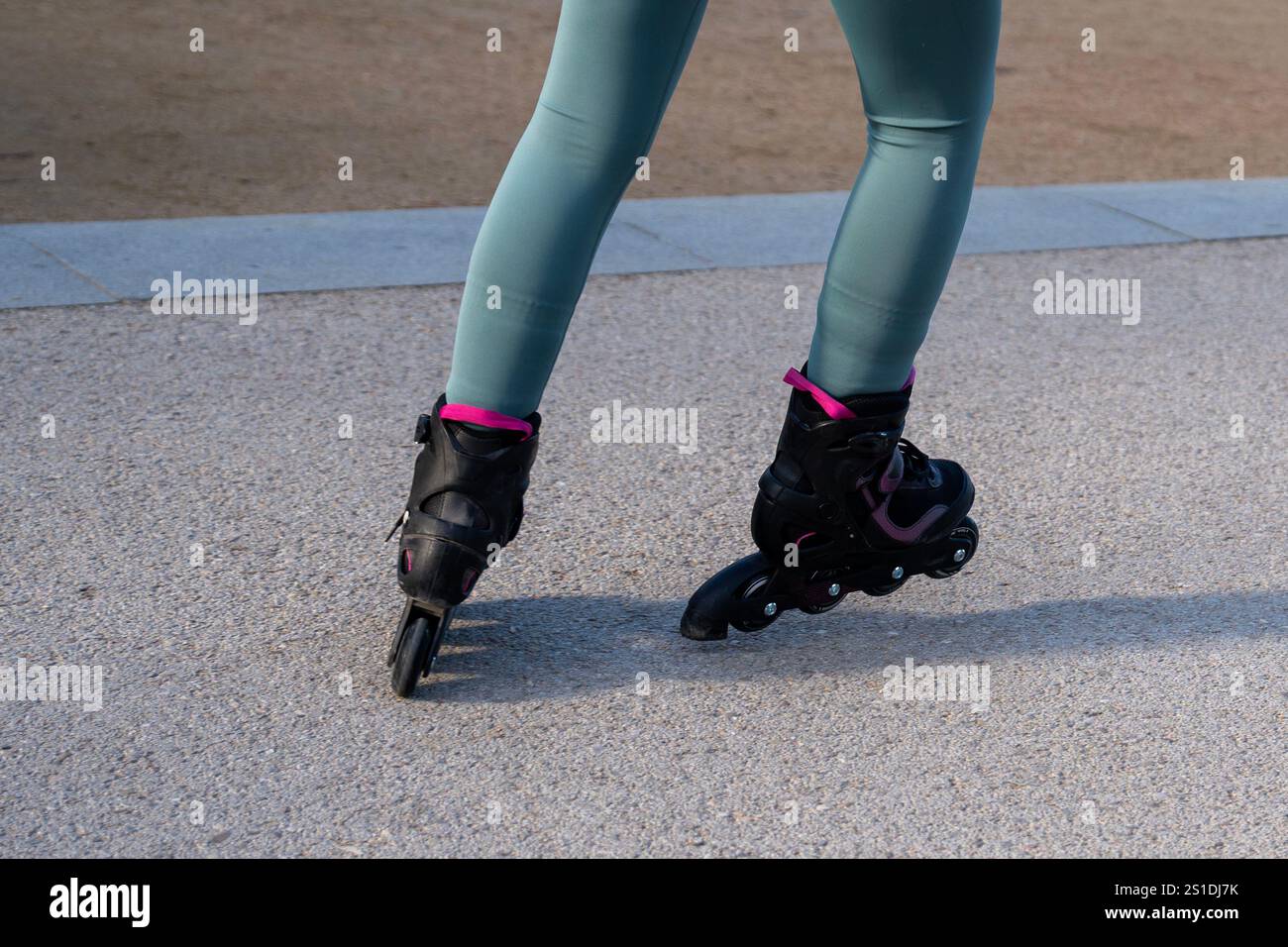 Nahaufnahme der Beine einer Frau, die in einem Park Rollschuhlaufen und einen sonnigen Tag im Freien genießen Stockfoto