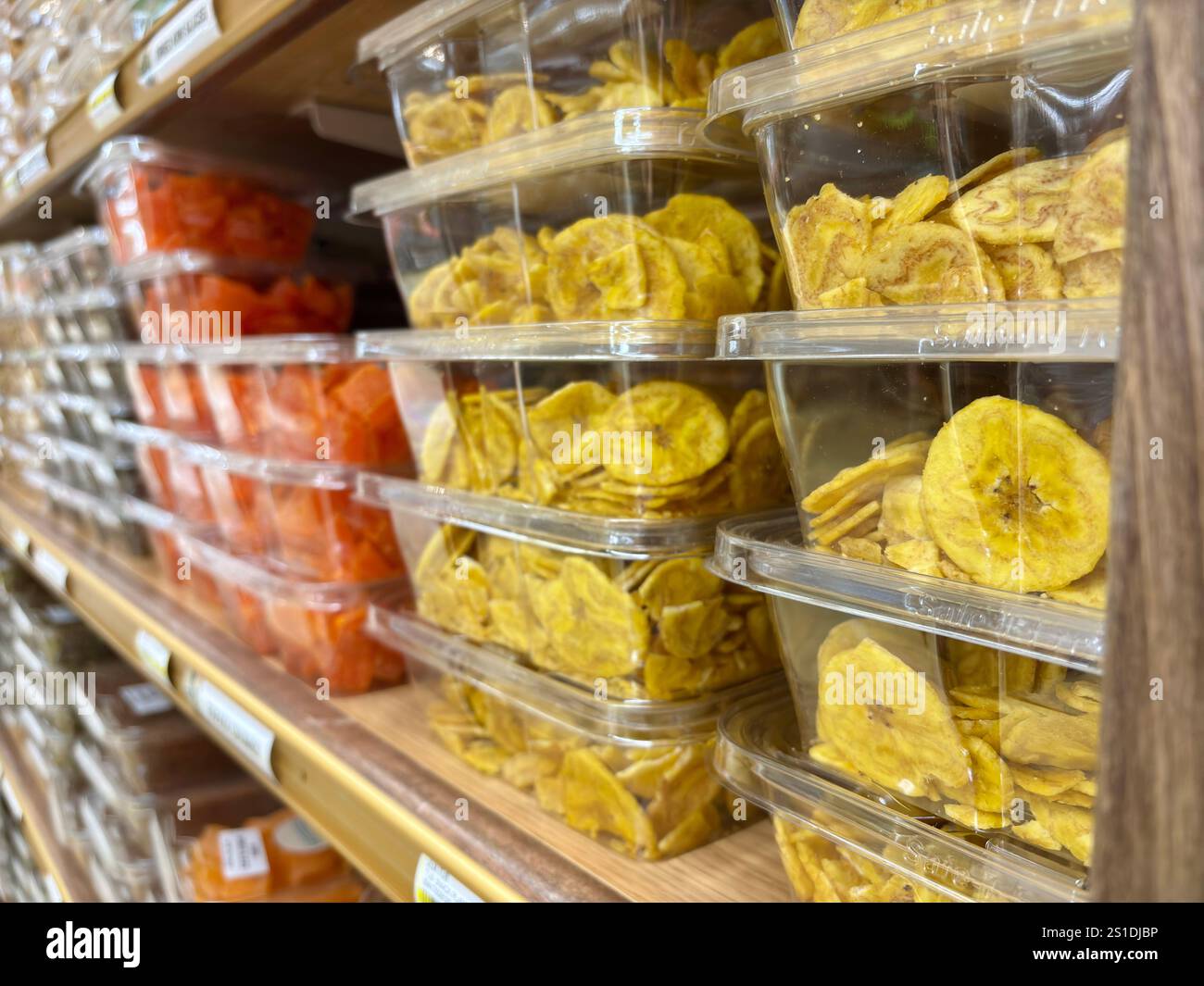 Nahaufnahme von Plastikbehältern gefüllt mit Bananenchips, getrockneten Früchten Stockfoto