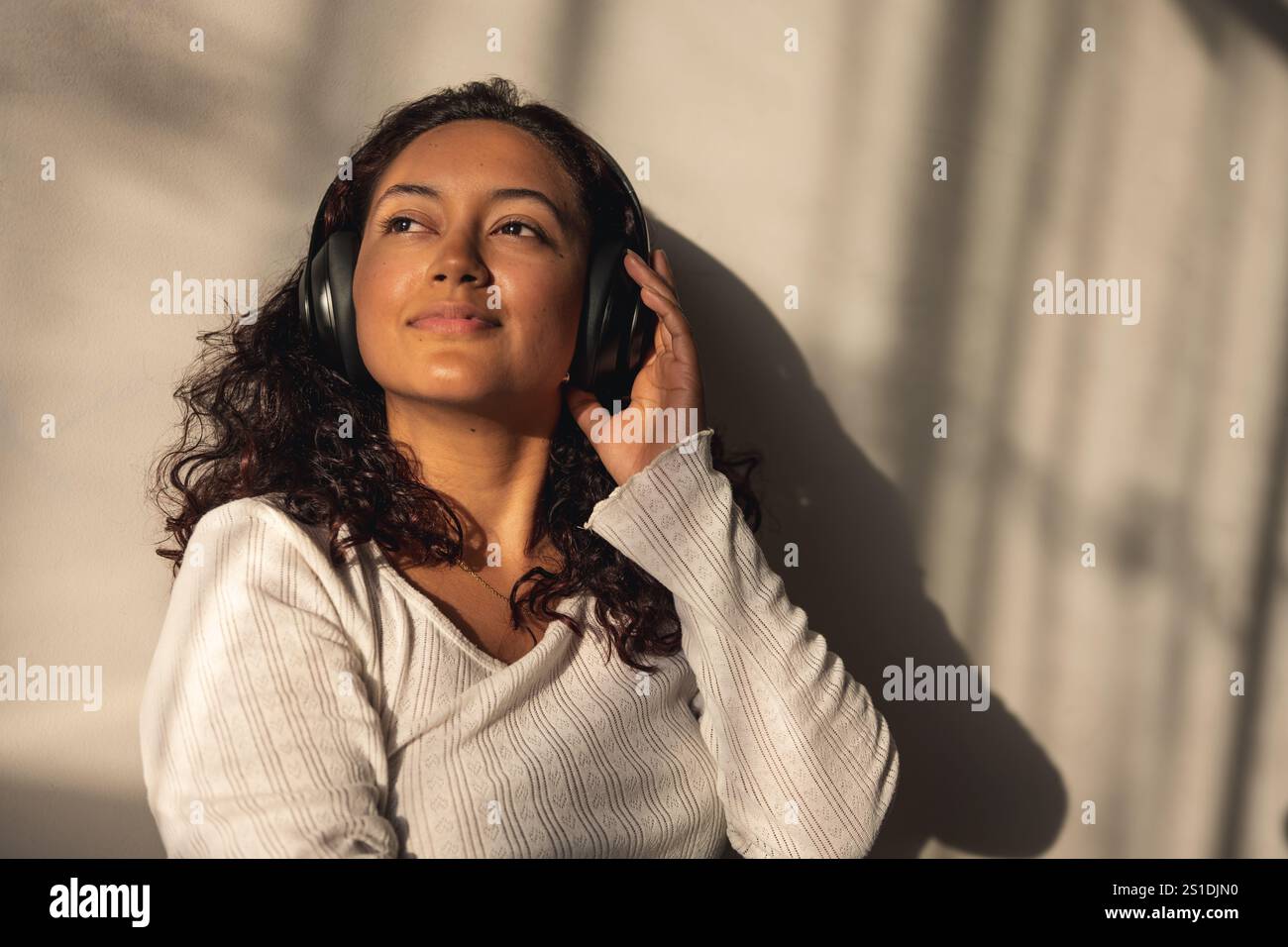 Entspannte Frau, die zu Hause Musik mit Kopfhörern hört Stockfoto