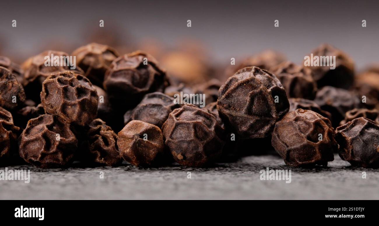 Pfefferkörner oder Schwarzpfeffer-Gewürz. Supermakro Nahaufnahme. Schwarzer Pfeffer ist eine blühende Rebe der Familie Piperaceae, die wegen ihrer Frucht angebaut wird Stockfoto