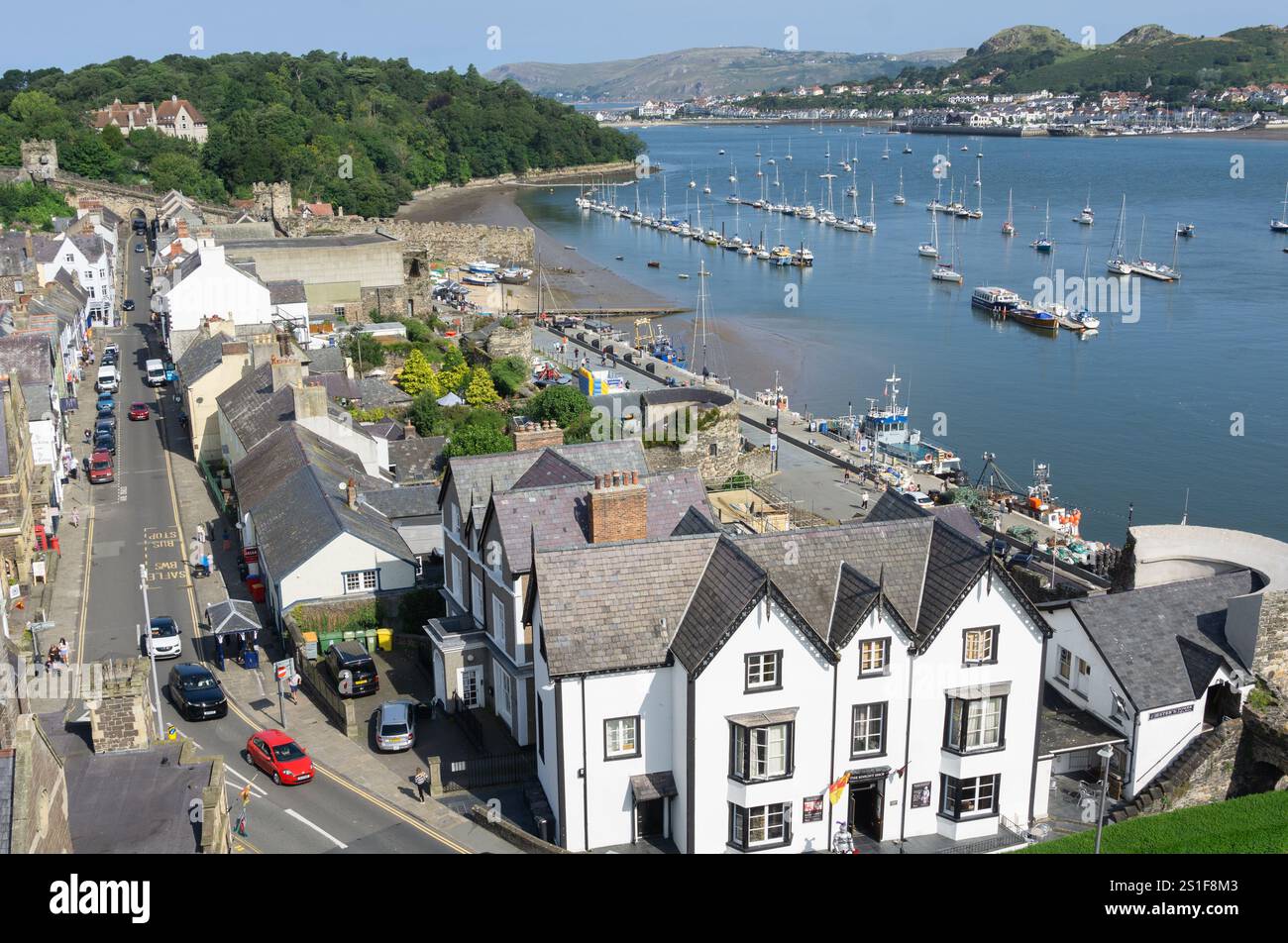 Conwy Wales - Juli 31 2024; Blick von Conwy Castle auf die Stadtstraße unten mit weiß-schwarzem Knight Shop im Vordergrund. Stockfoto