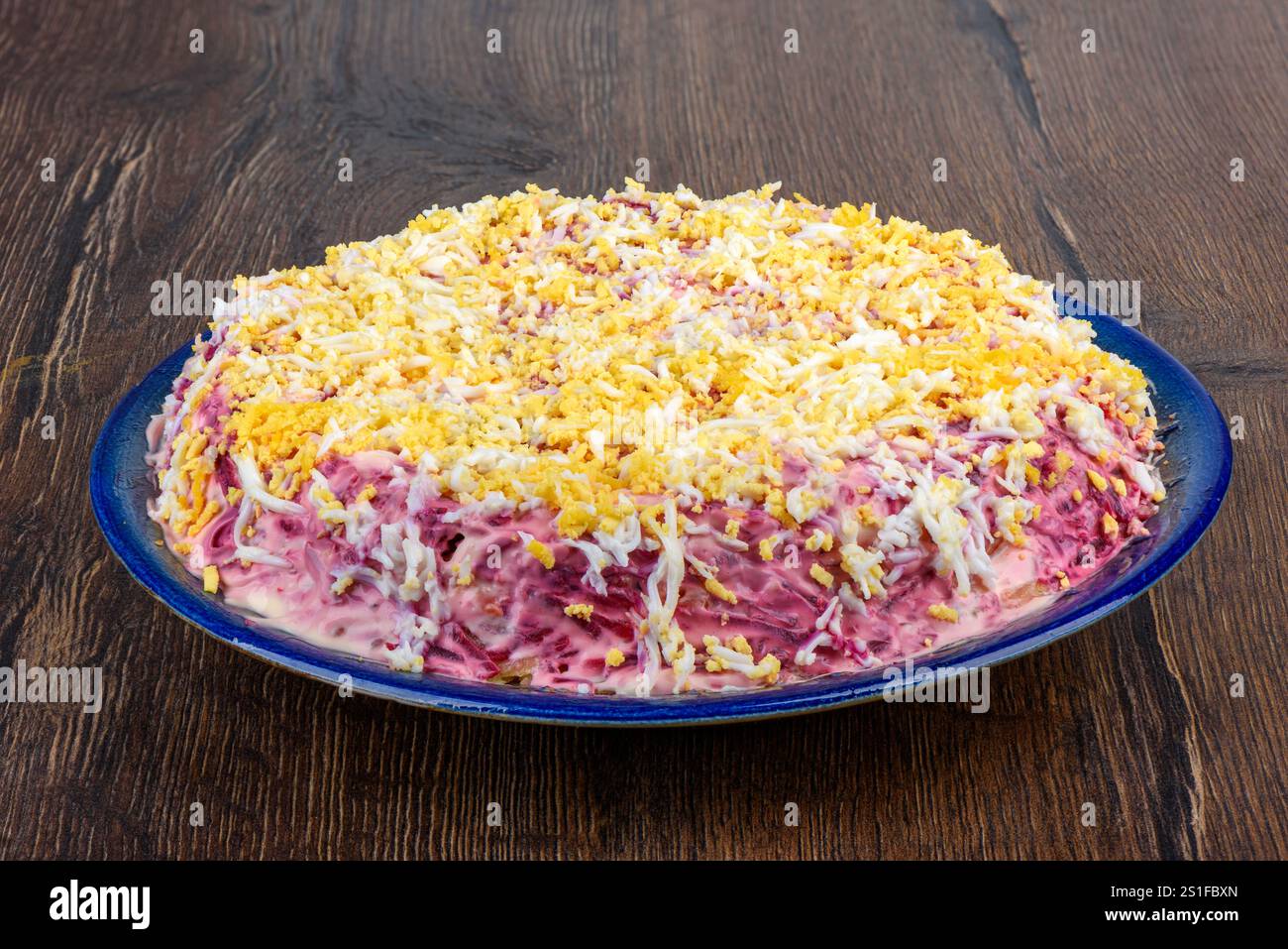 Traditioneller russischer Mehrschichtsalat Hering unter einem Pelzmantel aus gehacktem Hering, Rüben, Kartoffeln, Karotten und Eiern. Hausmannskost. Stockfoto