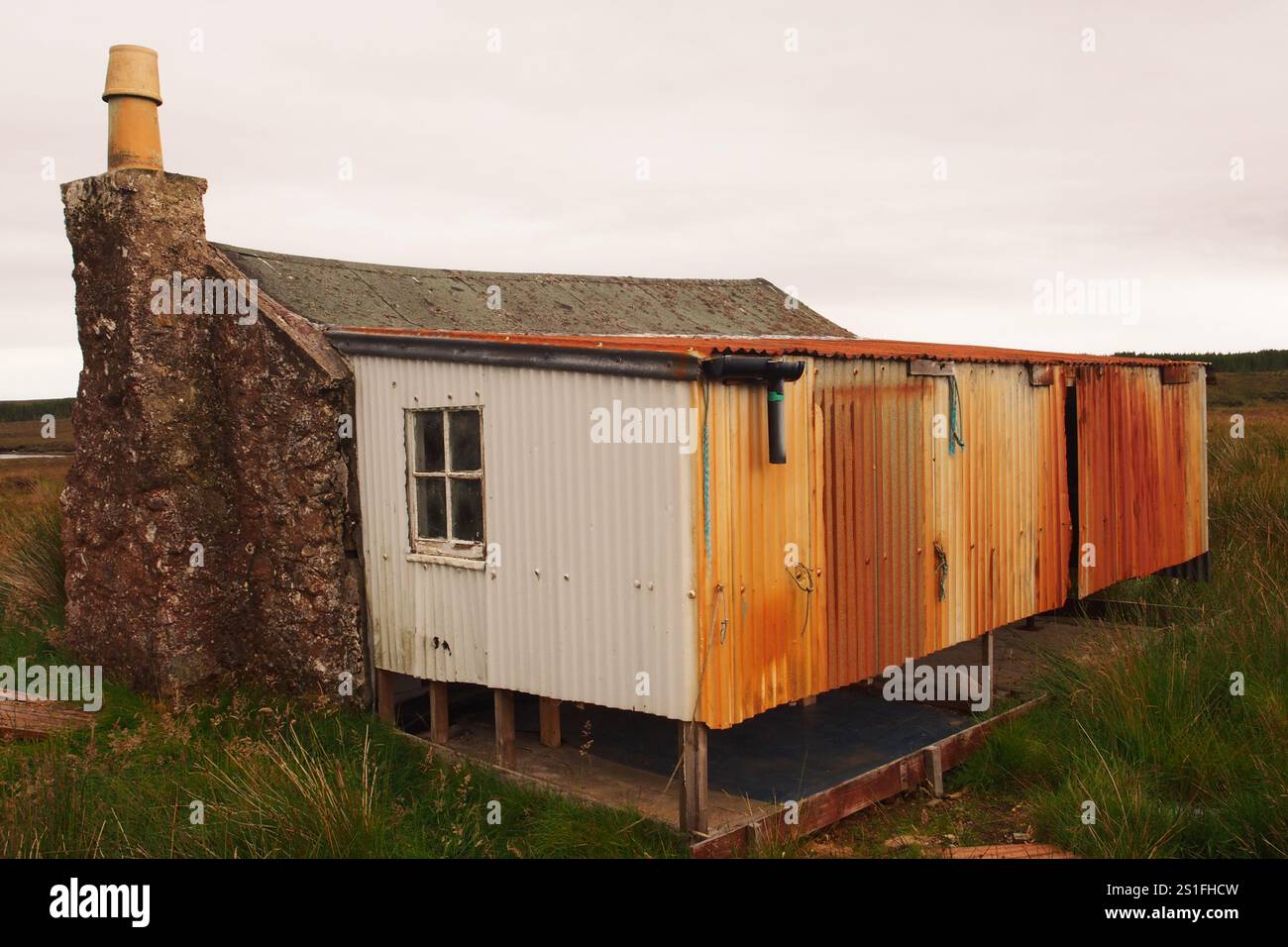 Eine schottische Bothy in einer abgelegenen Landschaft auf der Isle of Lewis, die das grundlegende Gebäude in der wilden Landschaft und die Notwendigkeit einer Reparatur zeigt Stockfoto