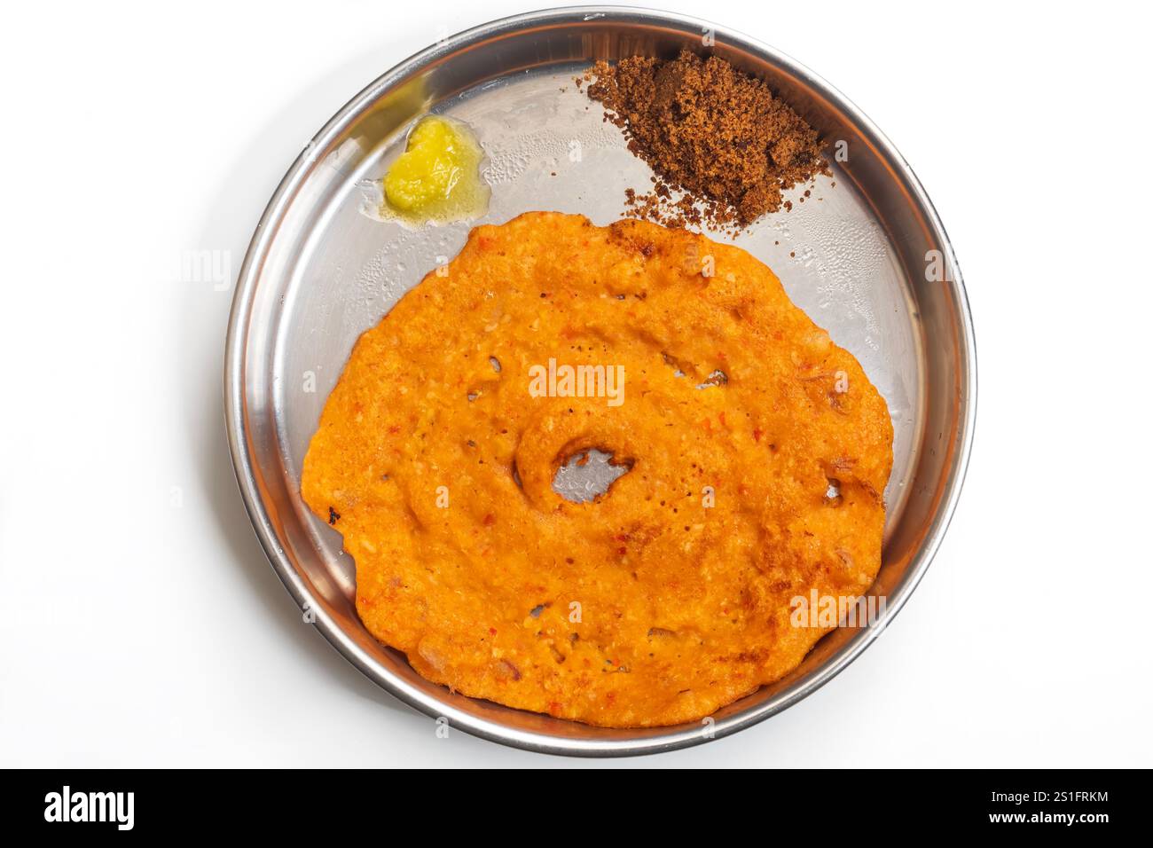Ein traditionelles indisches Gericht mit knusprigem Dosa, serviert auf einem Teller mit Landzucker und Ghee. Stockfoto