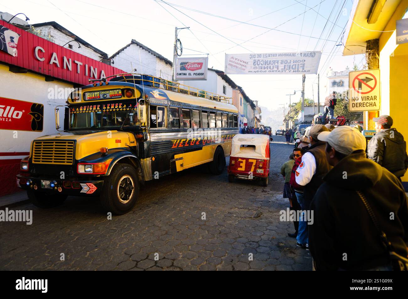 Bus in Chichicastenango Guatemala // CHICHICASTENANGO, Guatemala - Leute warten auf den Bus in Chichi. Chichicastenango ist eine indigene Maya-Stadt im guatemaltekischen Hochland, etwa 90 Meilen nordwestlich von Guatemala City und auf einer Höhe von fast 6.500 Metern. Am bekanntesten ist es für seine sonntäglichen und donnerstags stattfindenden Märkte. Stockfoto Bus in Chichicastenango Guatemala // CHICHICASTENANGO, Guatemala - Leute warten auf den Bus in Chichi. Chichicastenango ist eine indigene Maya-Stadt im guatemaltekischen Hochland, etwa 90 Meilen nordwestlich von Guatemala City und auf einer Höhe von fast 6.500 Metern. Am bekanntesten ist es für seine sonntäglichen und donnerstags stattfindenden Märkte. Stockfoto