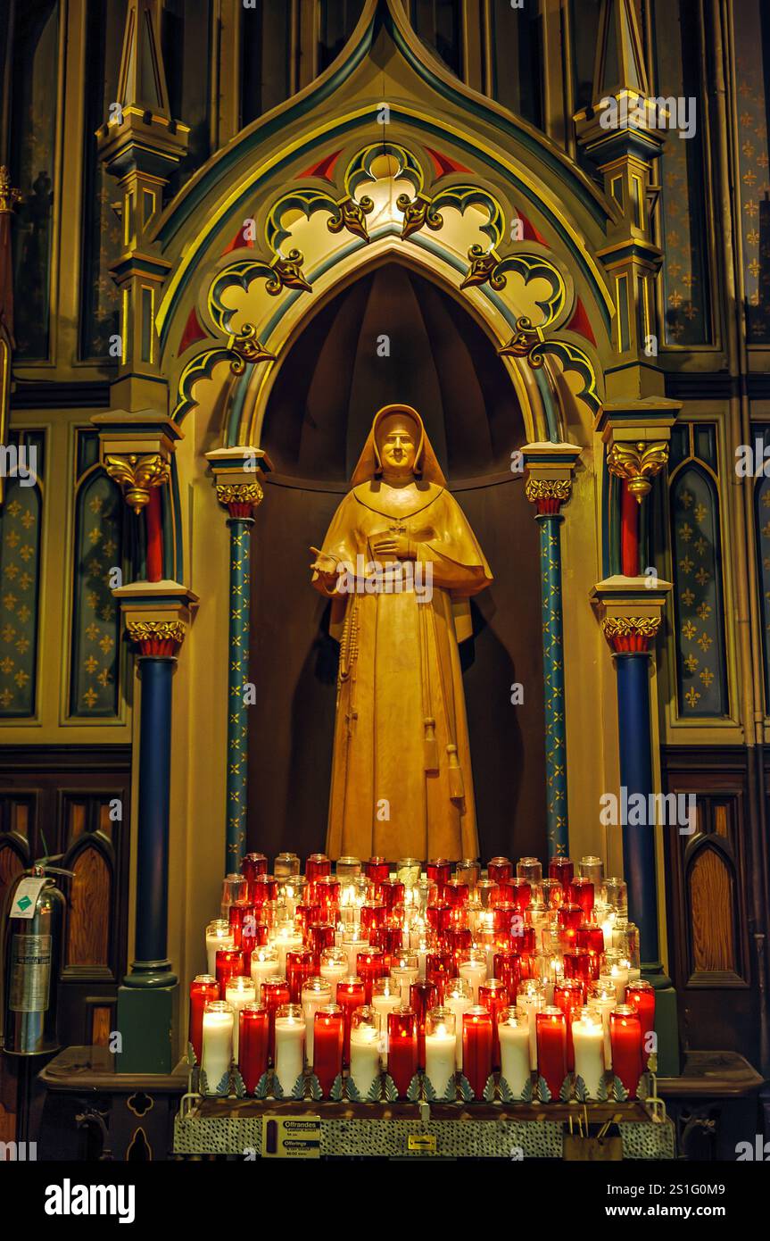 Notre-Dame Basilika nun Statue Montreal Kanada // MONTREAL, Kanada — Eine Statue einer Nonne steht im kunstvollen Inneren der Basilika Notre-Dame de Montreal. Die religiöse Skulptur wird in Québecs berühmtester katholischer Kirche ausgestellt, die für ihre reich verzierte Inneneinrichtung im Gothic Revival bekannt ist. Die Basilika Notre-Dame zieht jährlich Tausende von Besuchern an, die zu den bedeutendsten religiösen und historischen Wahrzeichen Montreals gehören. Stockfoto