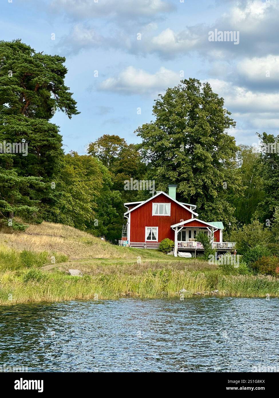 Bilder von einer Reise nach Schweden, die schwedische Flagge auf einer Stockholmer Insel, ein typisch schwedisches Haus im skandinavischen Stil - Smartphone-aufgenommenes Stockfoto