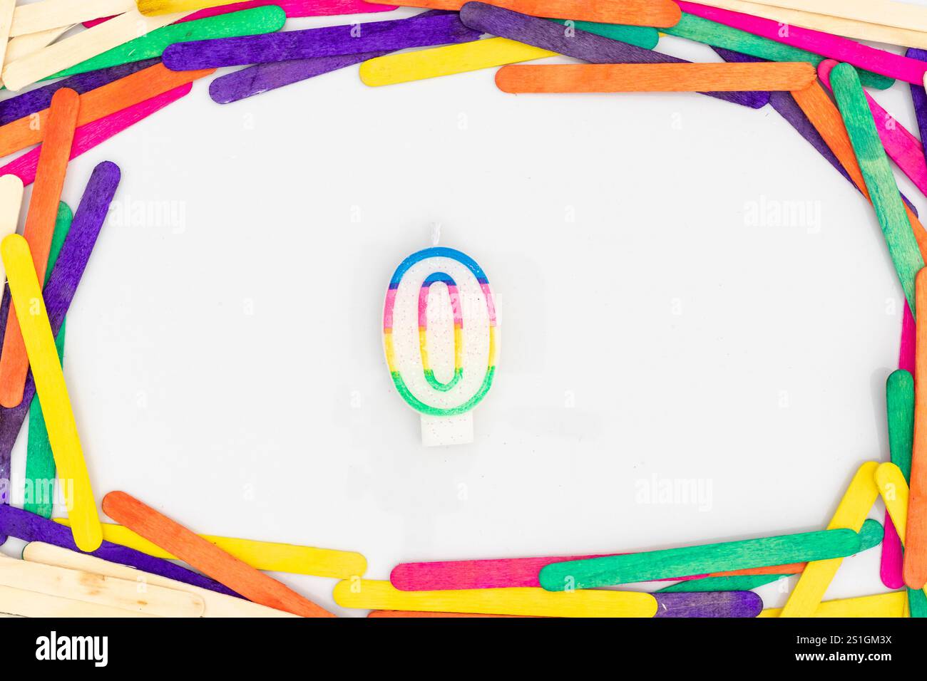 Bunte Null-Zahl-Form Regenbogenfarben Kerze in bunten Holzstäbchen Rand Hintergrund Stockfoto