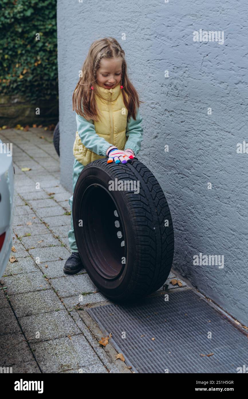 Eine Tochter hilft ihrem Vater, die Reifen im Auto zu wechseln, und teilt dabei während der Aufgabe einen Bindemoment. Hochwertige Abbildung Stockfoto