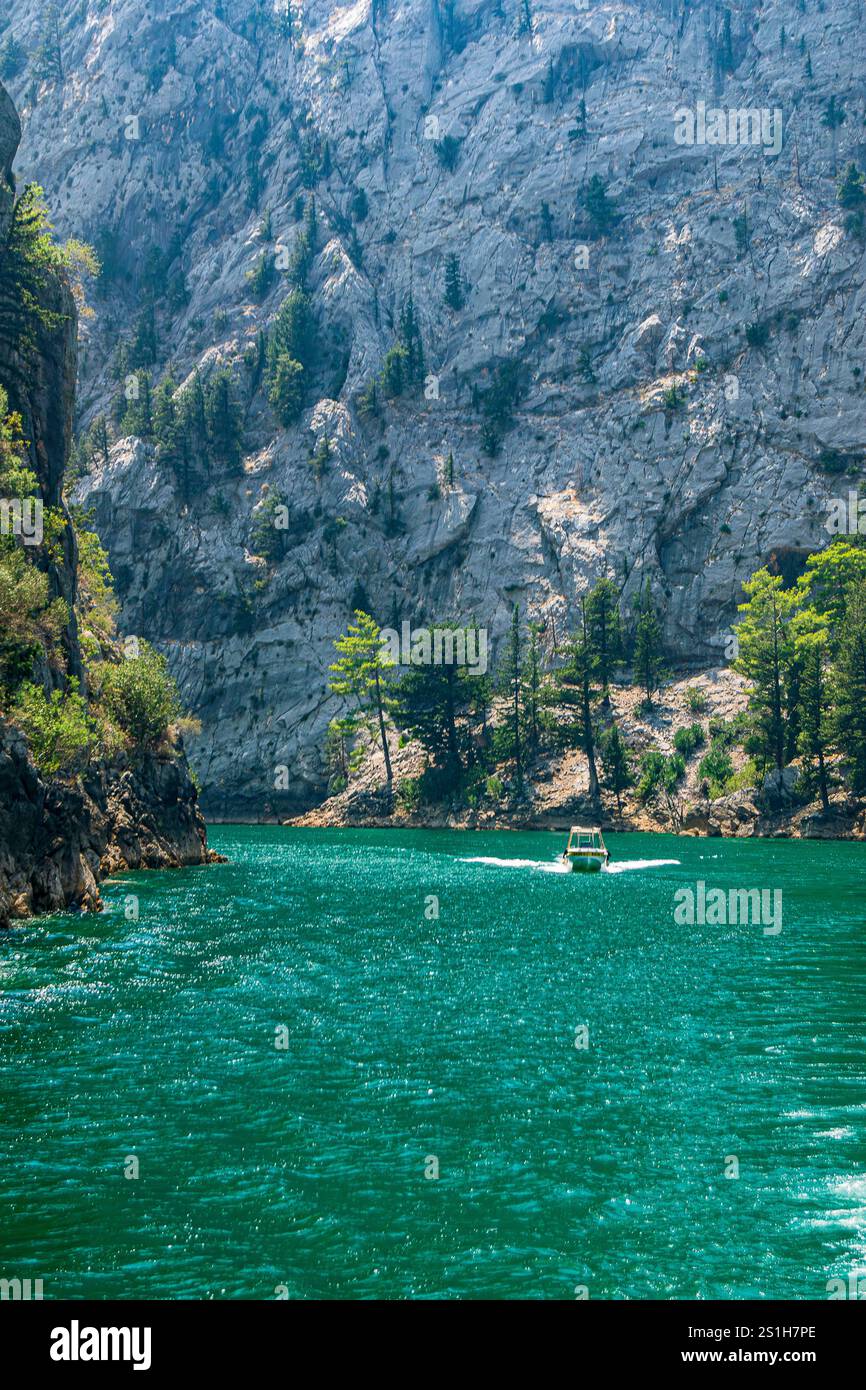 Schöne malerische Bootsaufnahme auf dem Green Canyon Wasser in einer wunderschönen rauen Landschaft vor blauem Himmel am Oymapinar Reservoir, Manavgat, Türkiye Stockfoto