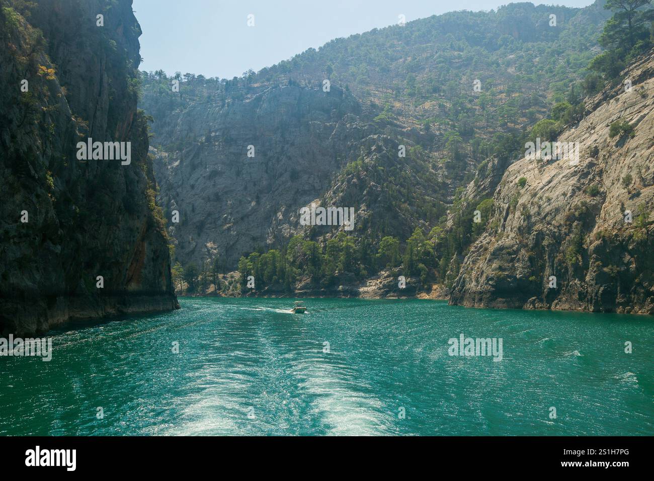 Schöne malerische Bootsaufnahme auf dem Green Canyon Wasser in einer wunderschönen rauen Landschaft vor blauem Himmel am Oymapinar Reservoir, Manavgat, Türkiye Stockfoto