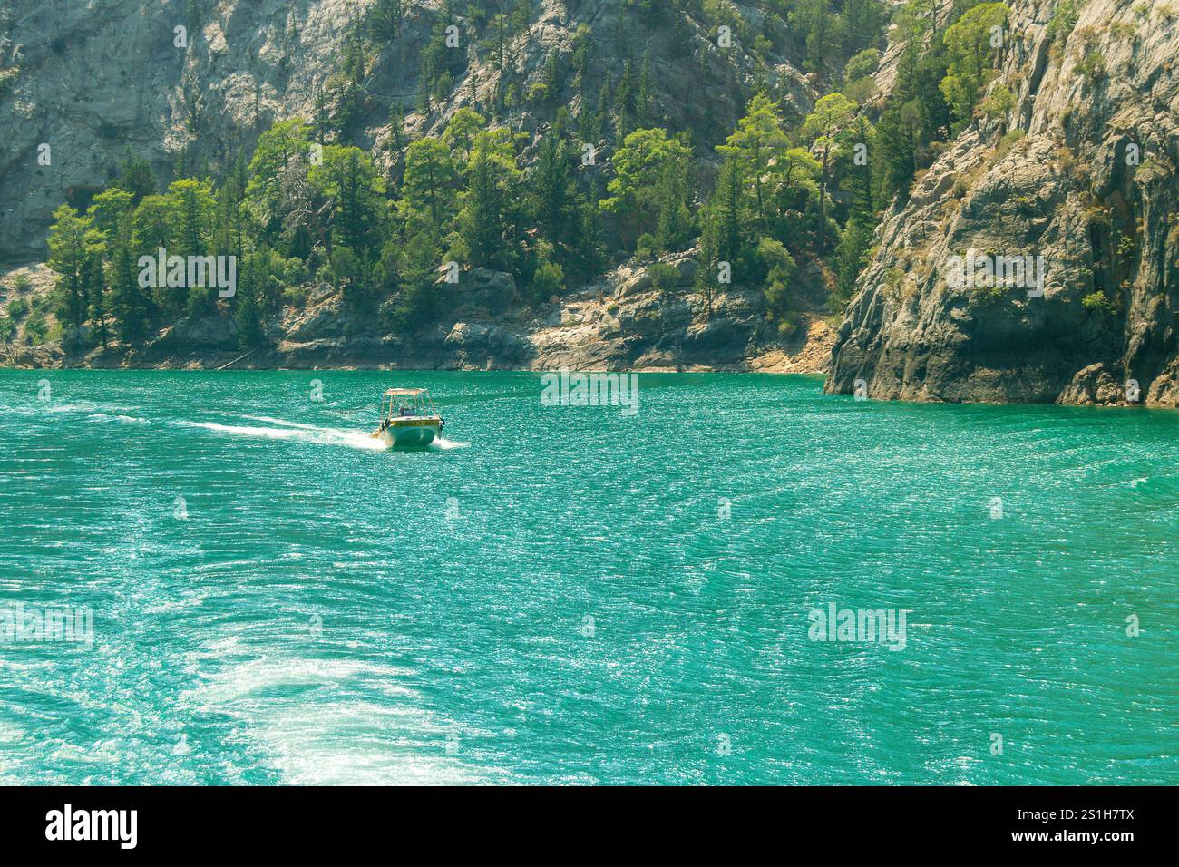Schöne malerische Bootsaufnahme auf dem Green Canyon Wasser in einer wunderschönen rauen Landschaft vor blauem Himmel am Oymapinar Reservoir, Manavgat, Türkiye Stockfoto