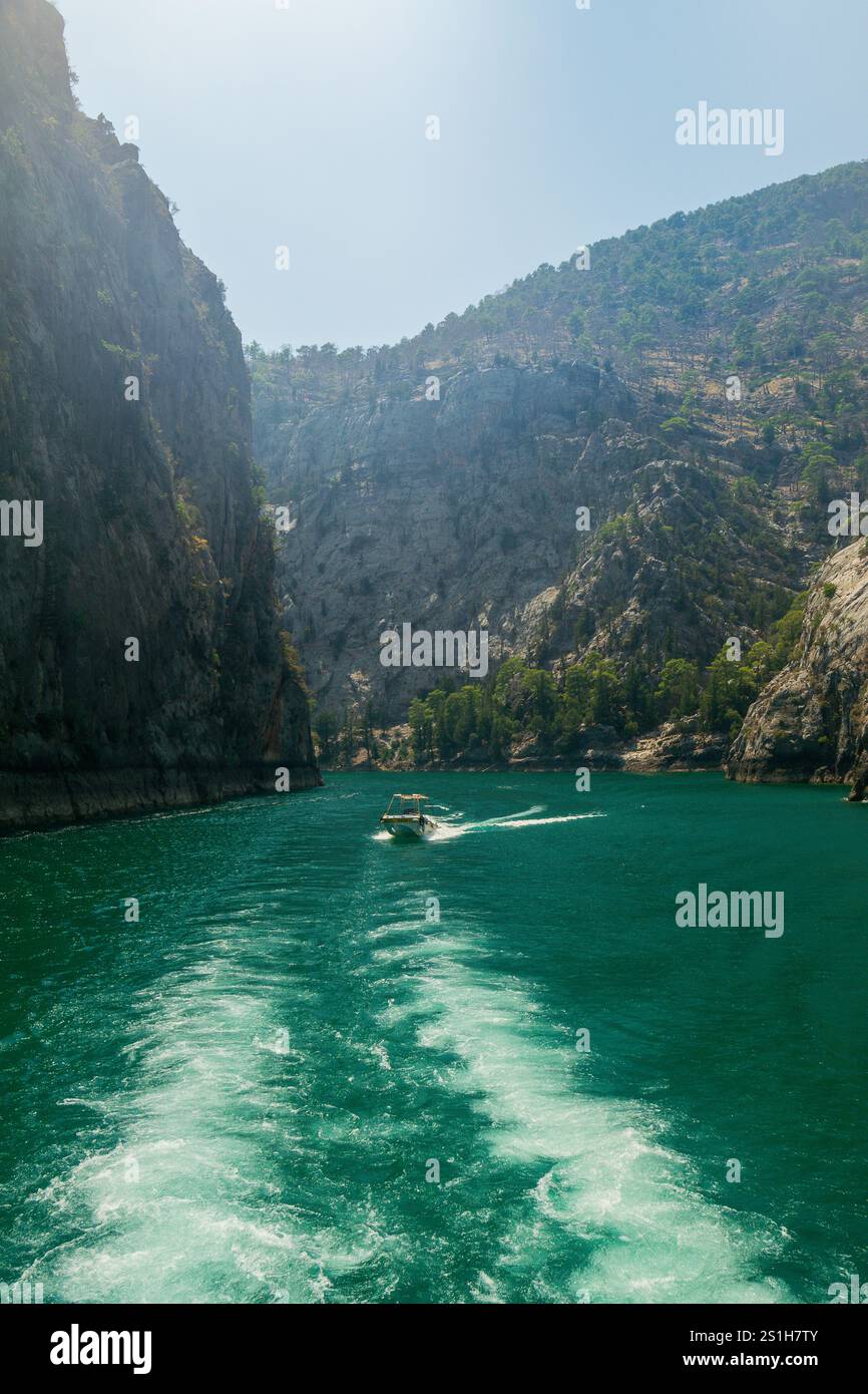 Schöne malerische Bootsaufnahme auf dem Green Canyon Wasser in einer wunderschönen rauen Landschaft vor blauem Himmel am Oymapinar Reservoir, Manavgat, Türkiye Stockfoto