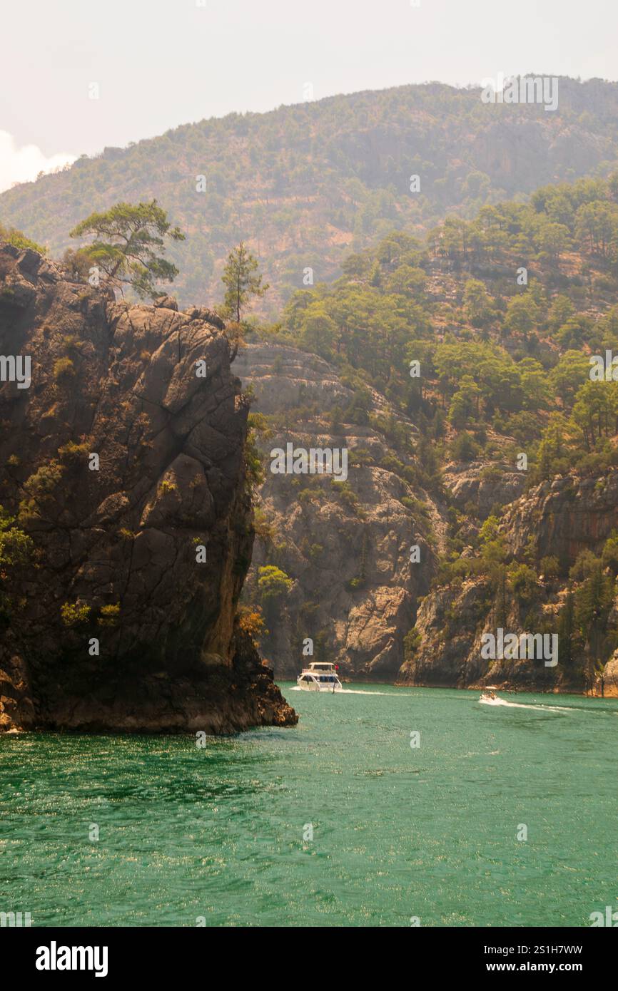 Schöne malerische Bootsaufnahme auf dem Green Canyon Wasser in einer wunderschönen rauen Landschaft vor blauem Himmel am Oymapinar Reservoir, Manavgat, Türkiye Stockfoto