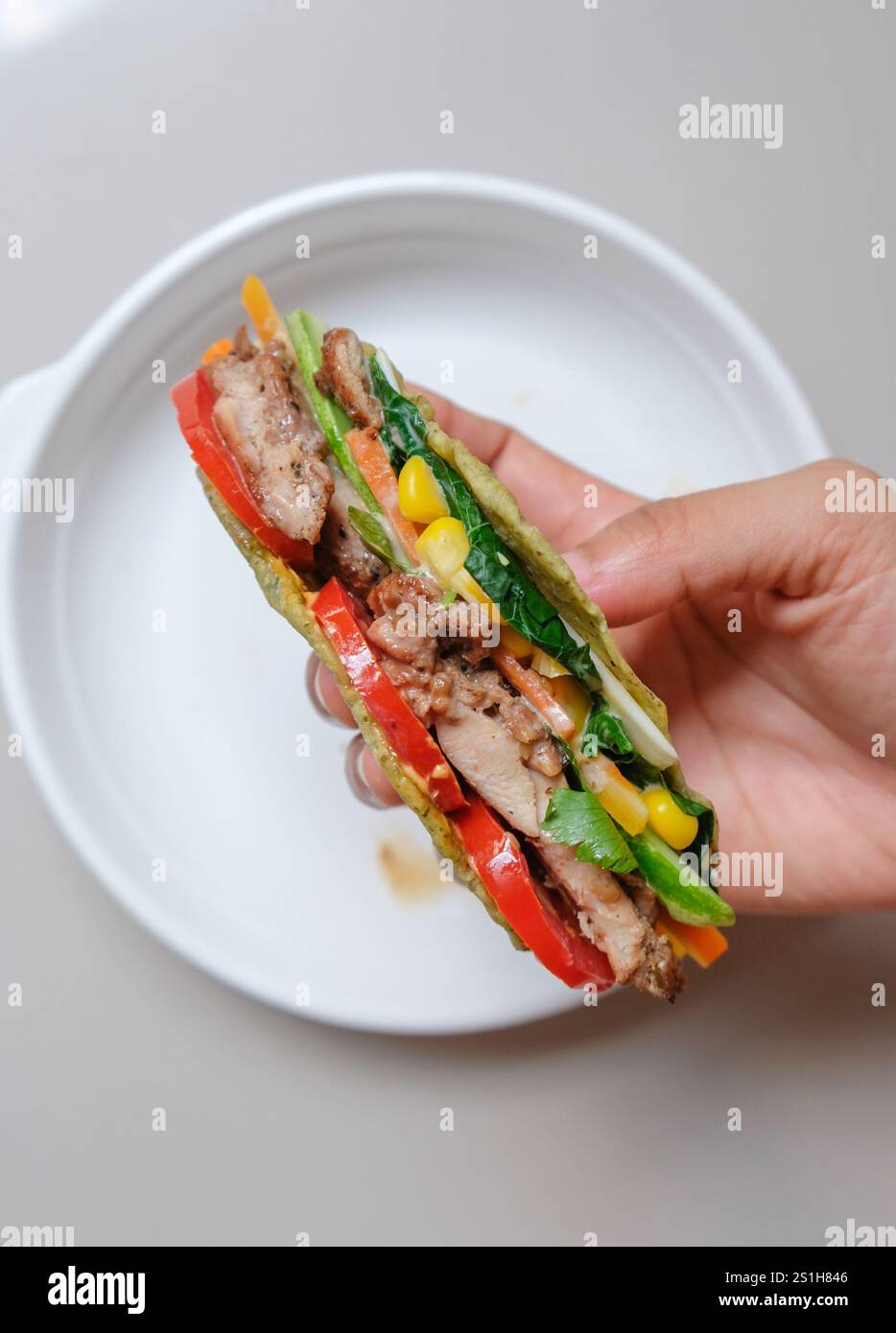 Tortilla-Wrap mit gebratenem Huhn und Gemüse. Stockfoto