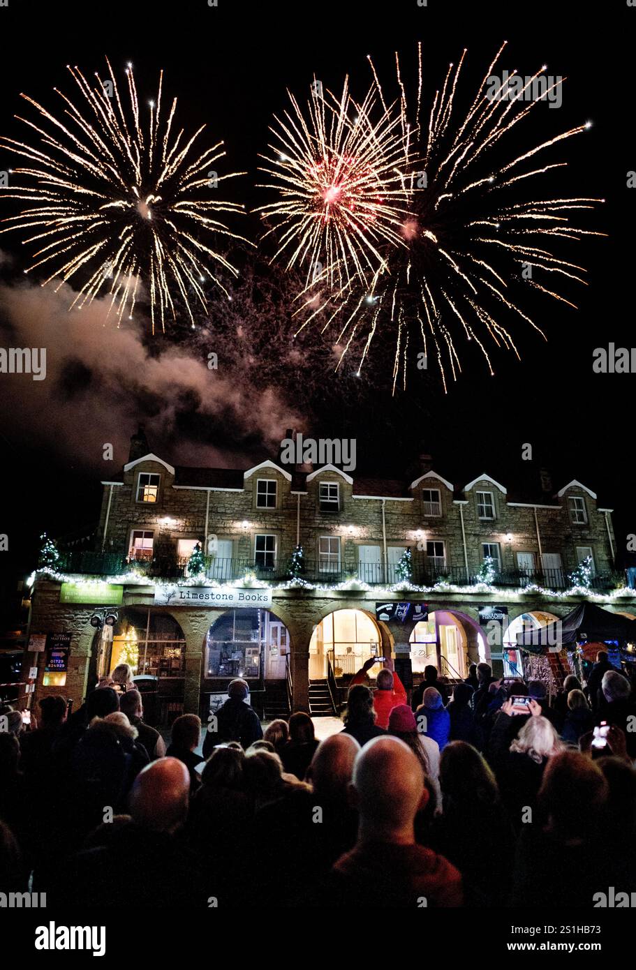 Feuerwerk über dem historischen Gebäude, bekannt als The Shambles in Settle, North Yorkshire, markiert das Einschalten der Weihnachtsbeleuchtung. Stockfoto
