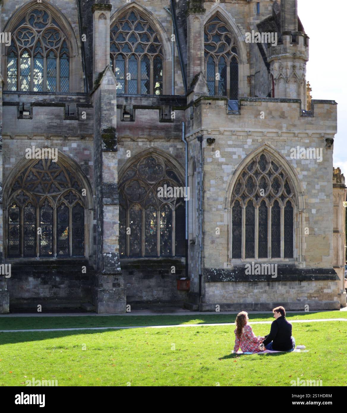 Ein junges Paar, das auf einem Kathedralengarten in Exeter, devon, großbritannien picknickt Stockfoto
