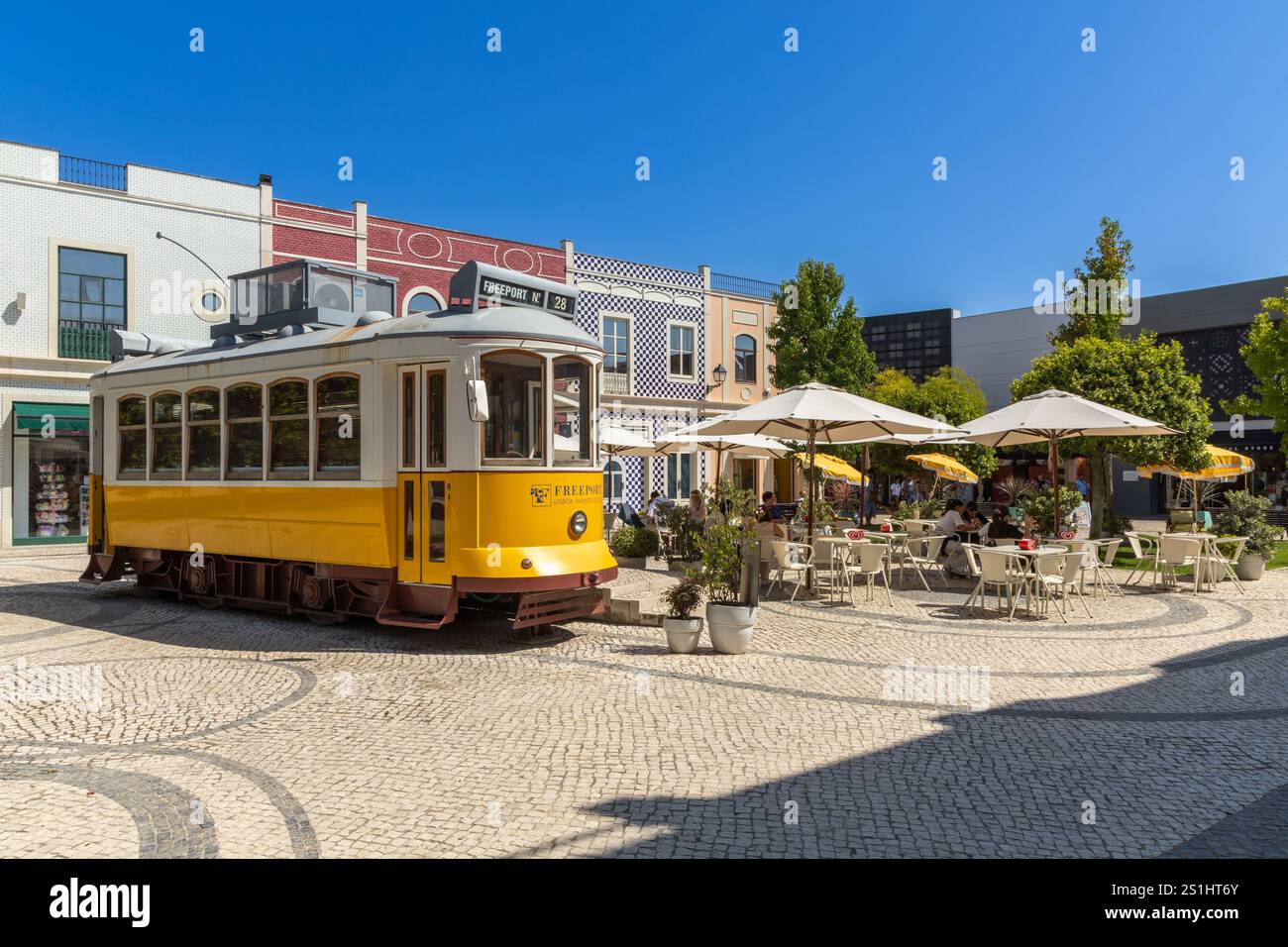 Alcochete, Portugal. 9. August 2024, Lissabon Tram 28 als Bar auf einem Platz mit Terrasse im Einkaufszentrum Freeport Fashion Outlet Stockfoto
