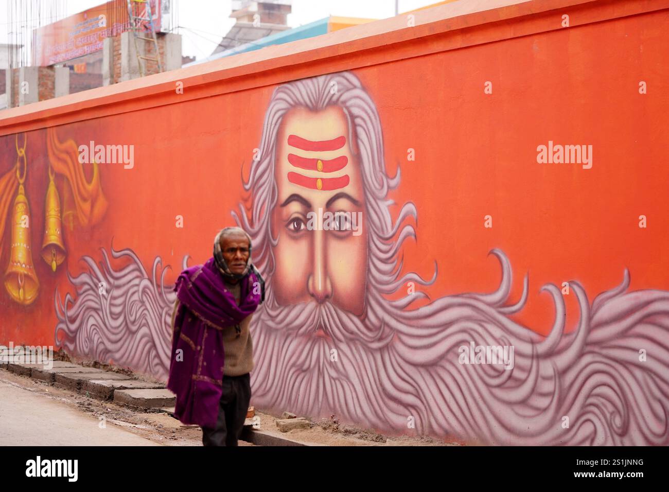 Prayagraj, Indien. Januar 2025. Die Indianer spazieren an einem Wandgemälde vorbei, vor dem Maha Kumbh Mela Festival in Prayagraj, Indien am 2. Januar 2025. Foto: Himanshu Sharma/ABACAPRESS. COM Credit: Abaca Press/Alamy Live News Stockfoto