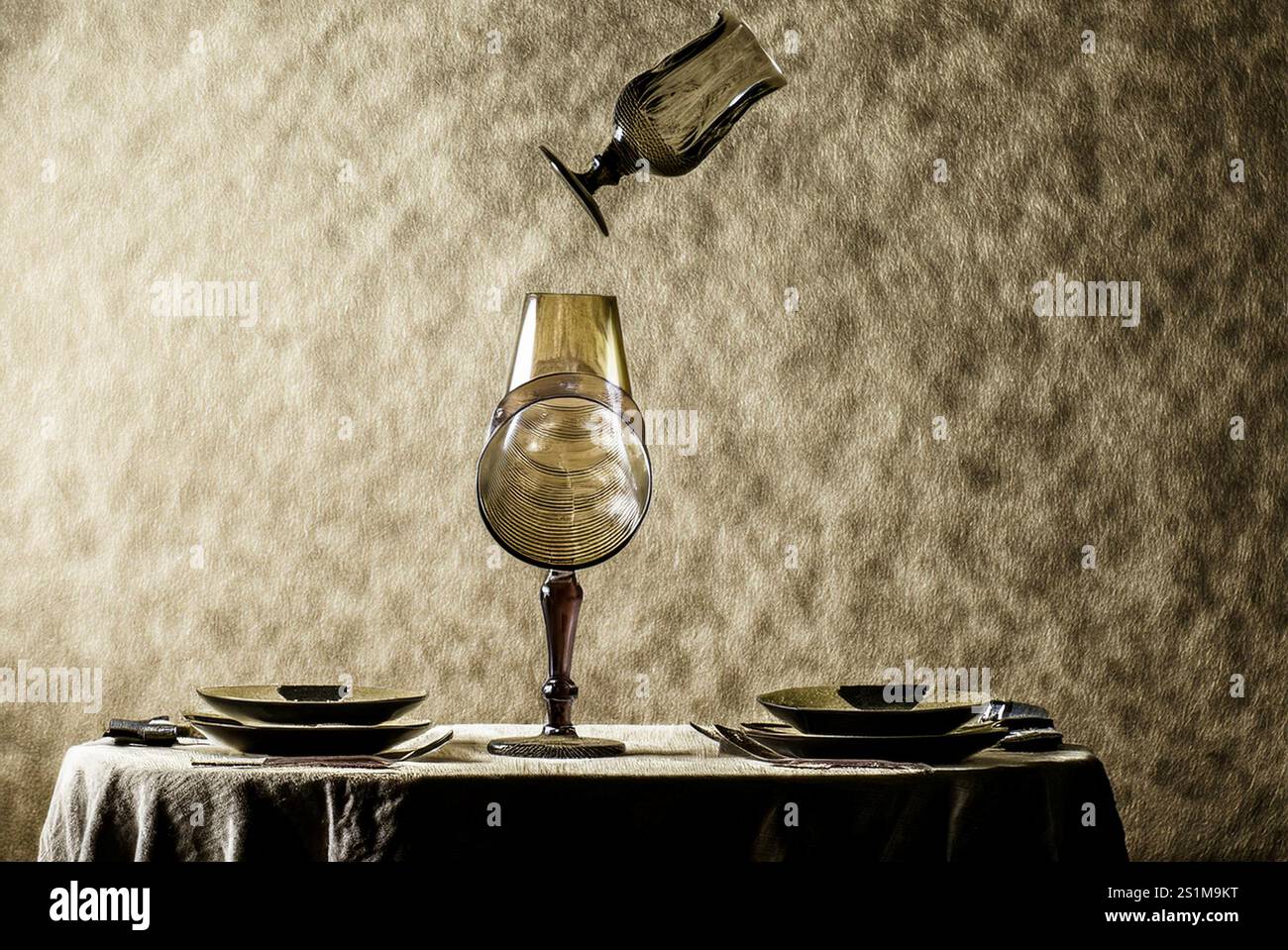 ABENDESSEN FÜR UNSICHTBARE: Ein Glas schwingt über einem voll vorbereiteten Esstisch. Stockfoto