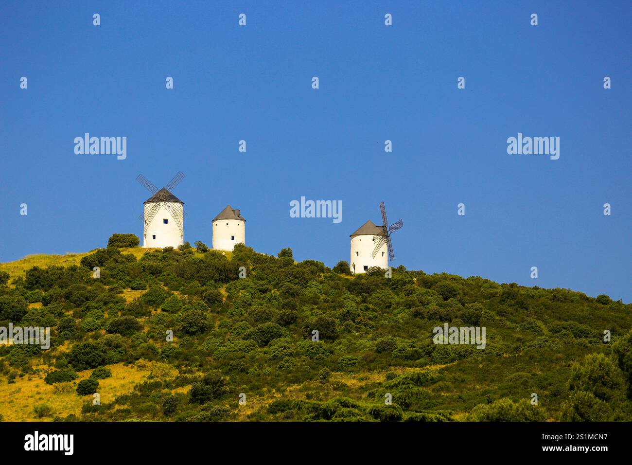 Drei alte spanische Windmühlen auf einem Hügel. Stockfoto