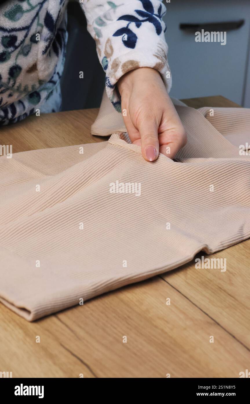 Eine Frau überprüft Thermoleggings. Zeigt Designelemente. Nahaufnahme. Stockfoto