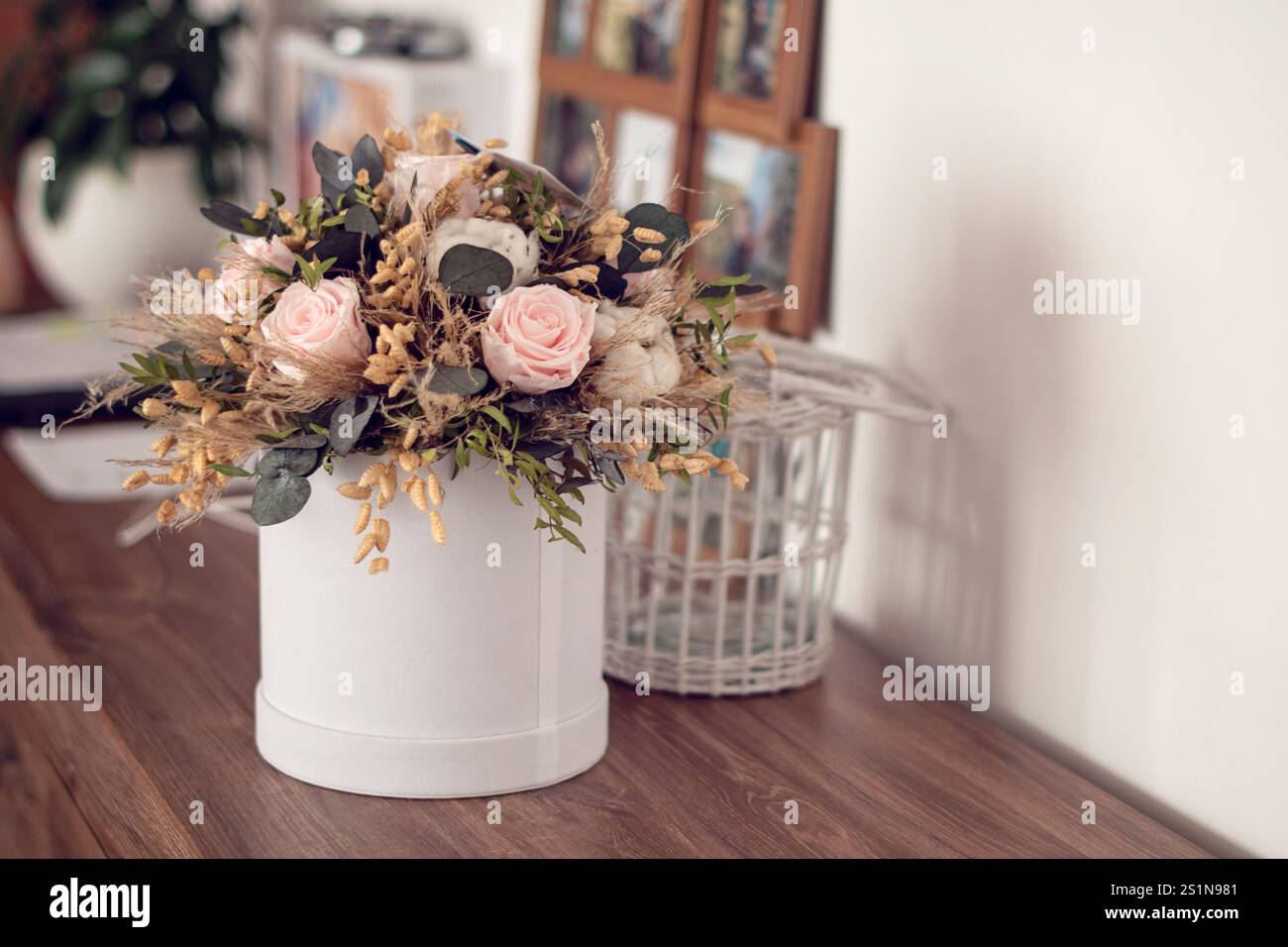 Langlebige Blumendekoration. Konservierte Rosen mit getrockneten Blumenstraußen aus der Nähe. Wohndekoration aus stabilisierten ewigen Pflanzen. Stockfoto