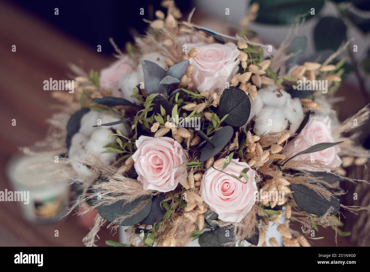 Langlebige Blumendekoration. Konservierte Rosen mit getrockneten Blumenstraußen aus der Nähe. Wohndekoration aus stabilisierten ewigen Pflanzen. Stockfoto