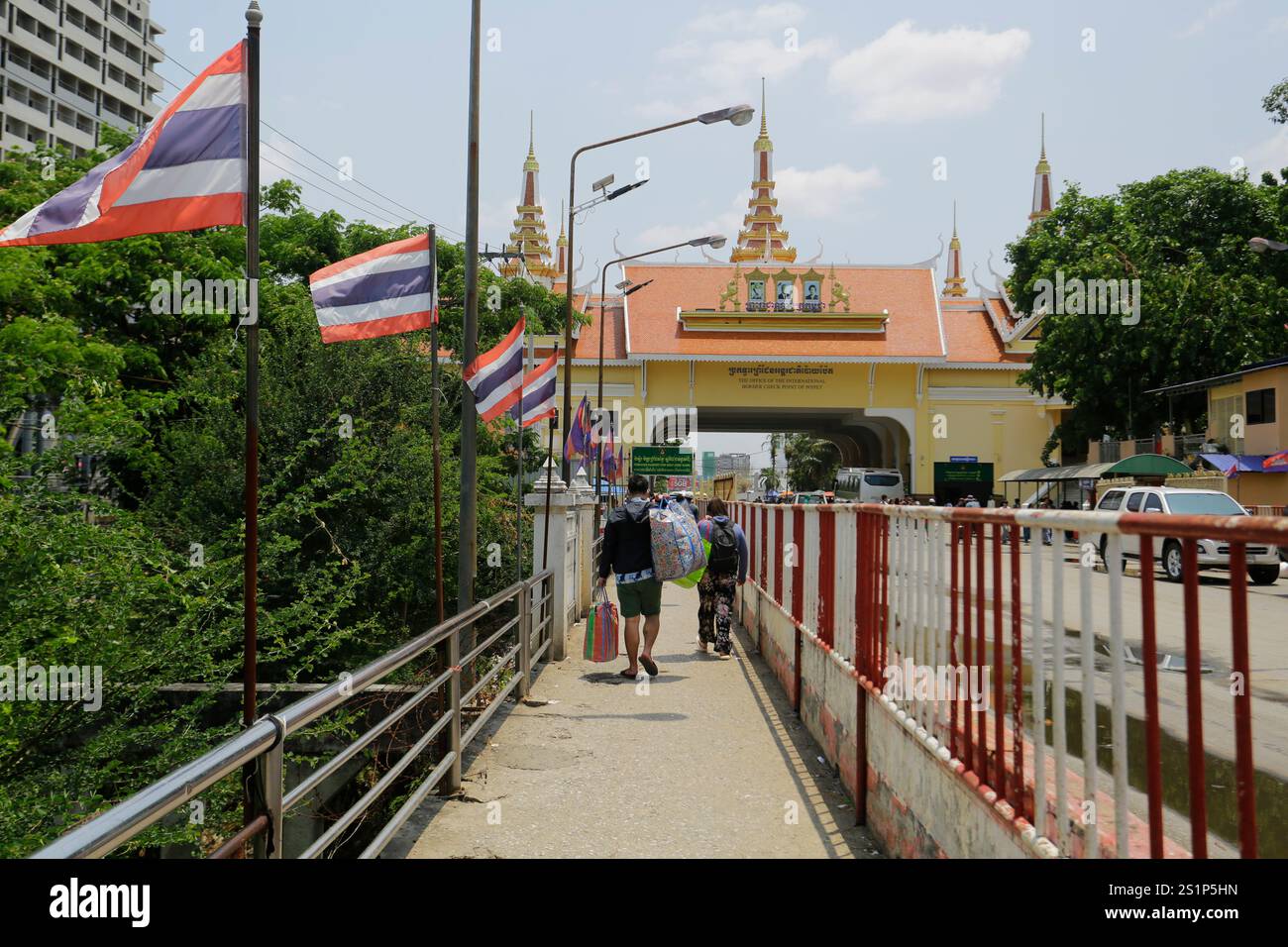 Poipet, Kambodscha - 30. März 2023: Menschen überqueren das internationale Grenztor von Kambodscha zu Thailand. Stockfoto