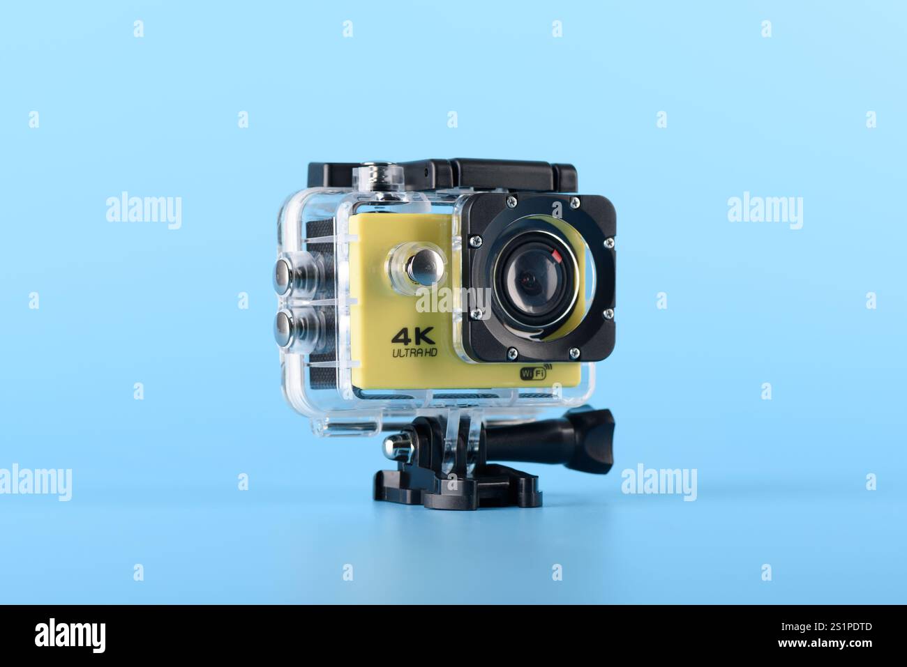 Moskau, Russland - 3. Januar 2025: Gelbe 4K-Action-Kamera in einem wasserdichten Gehäuse auf blauem Hintergrund, mit moderner Kompakttechnologie zum Filmen Stockfoto