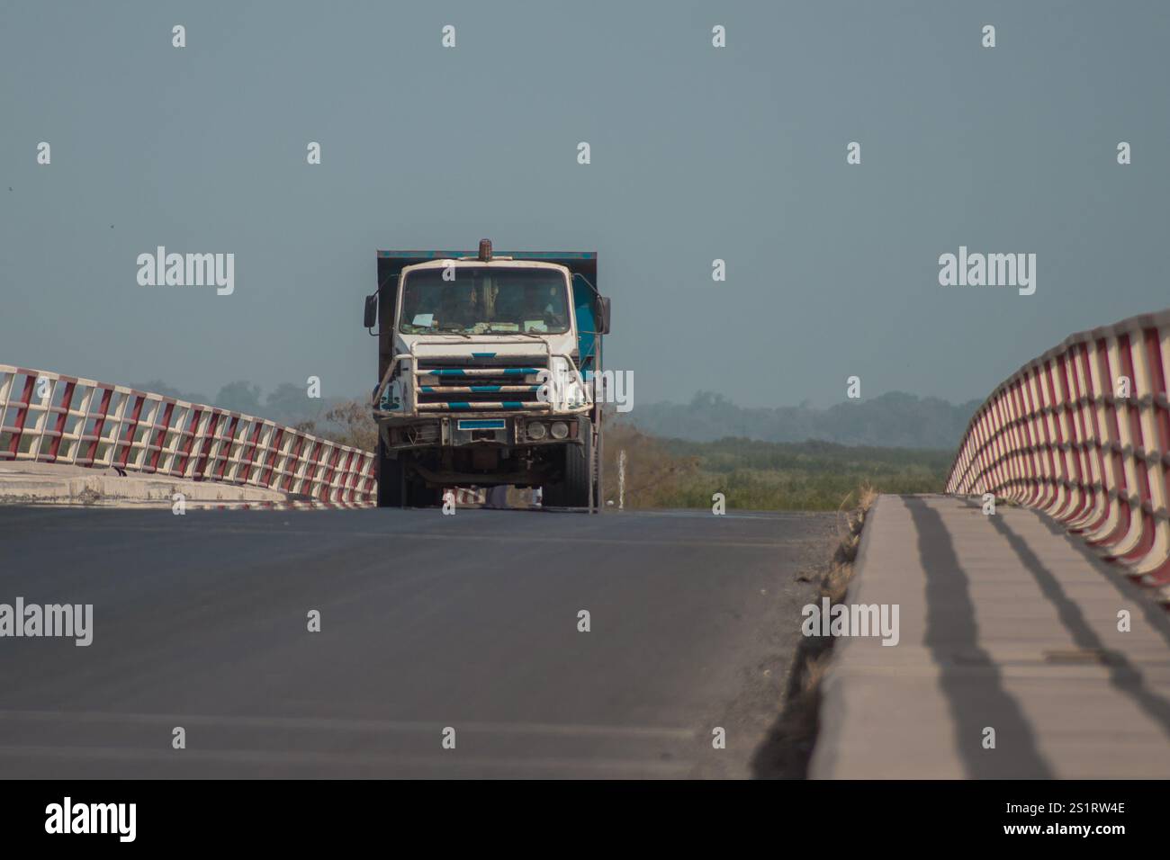 Lkw oder Lkw fahren über eine Brücke in ziguinchor im südlichen Teil des Senegals. Raue Straße über die Brücke des casamance River, sonniger Tag Stockfoto