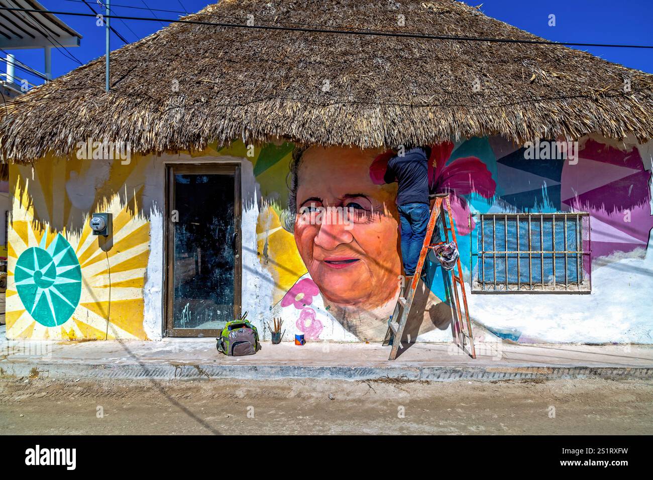Straßenkünstler malte buntes Wandgemälde auf dem rustikalen Strohdach, Isla Holbox, Mexiko Stockfoto