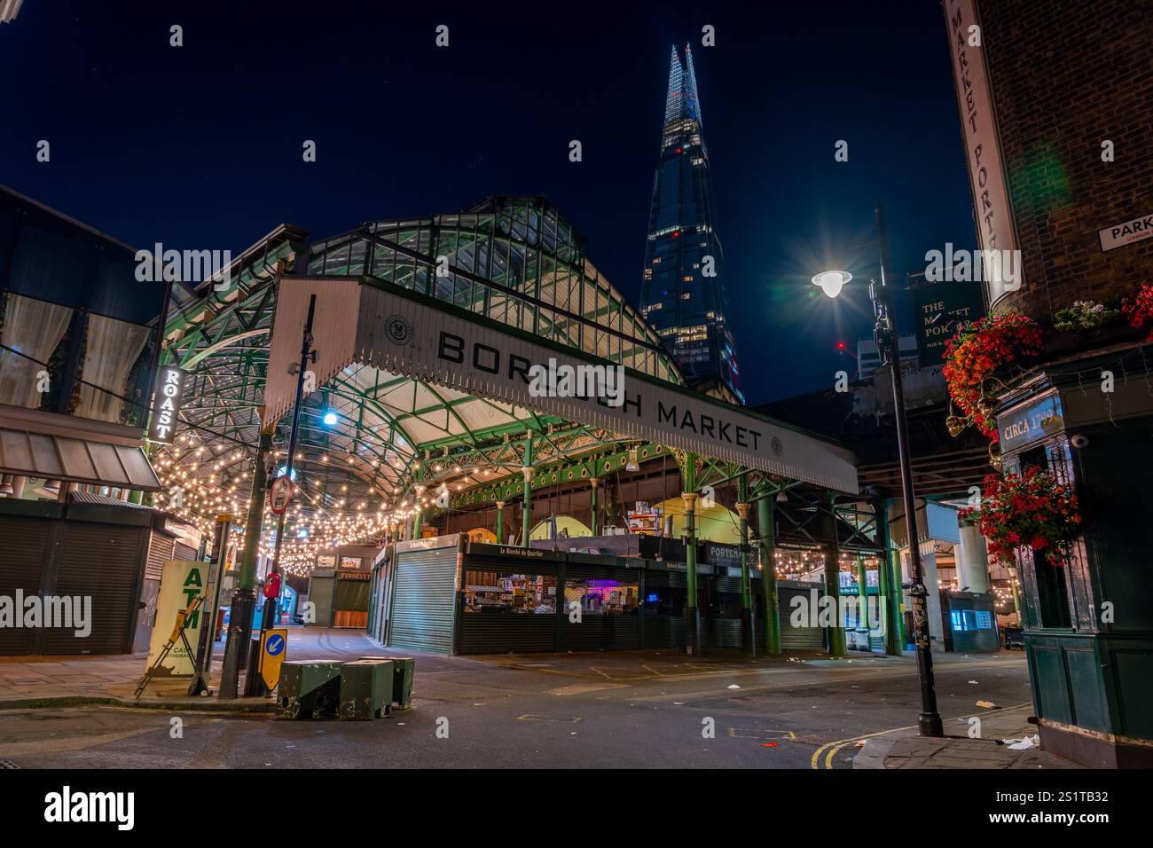 london, England - 6. August 2024 - Blick auf den Eingang des Borough Market bei Nacht mit hohen Wolkenkratzern im Hintergrund Stockfoto