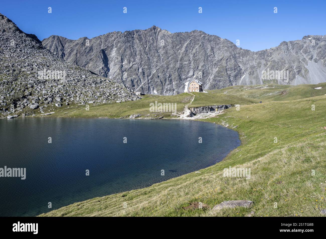 Felsige Berggipfel des Panargenkamms und Almhütte neue Reichenberger Hütte mit Bergsee Boedensee, Lasoerlinggruppe, hohe Tauern Nation Stockfoto