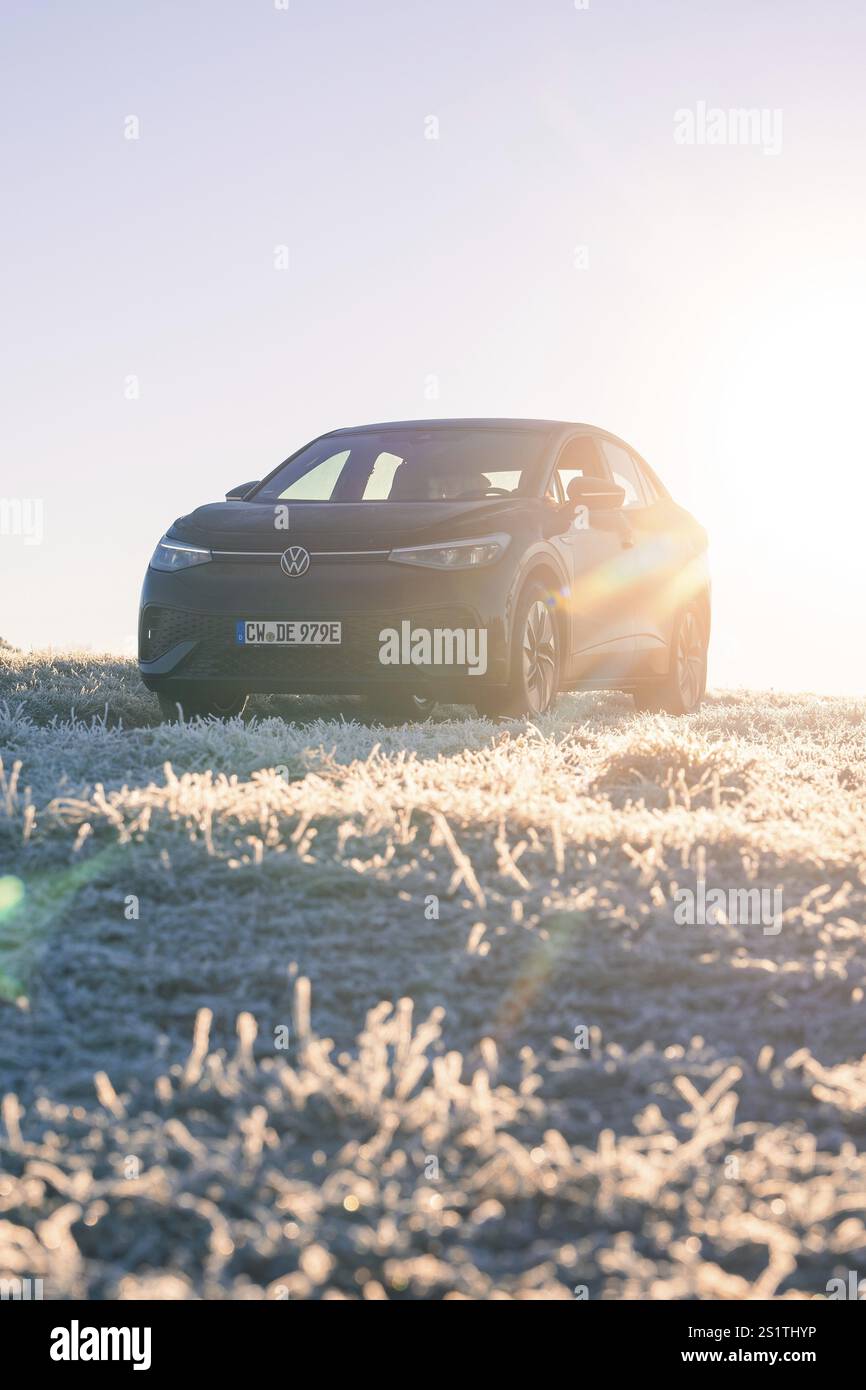 Ein Auto steht auf frostigem Boden im Morgenlicht mit Sonnenstrahlen, Car Sharing, Elektroauto, Volkswagen ID 5, Gechingen, Hecken und Gaeu Reg Stockfoto