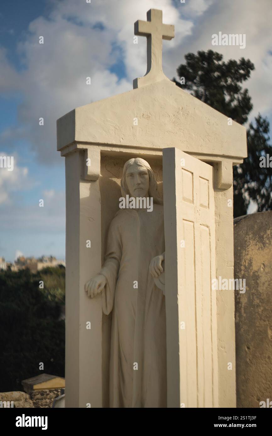 Skulptur von Jesus, der die Tür zum Himmel öffnet, auf einem Grabstein auf einem Friedhof in der Nähe von Valetta, Malta Stockfoto