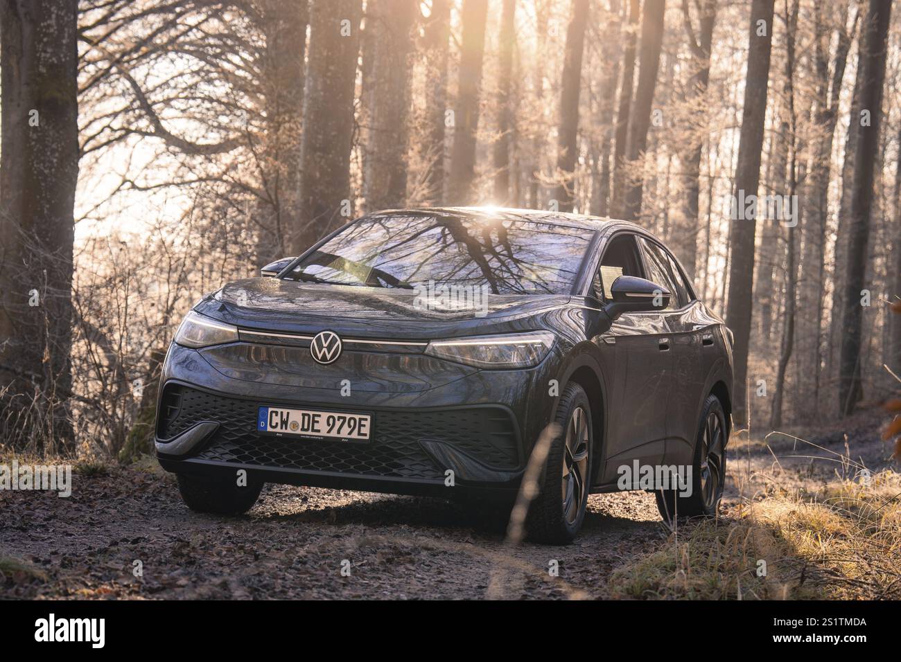 Schwarzes Auto auf einem Waldweg, umgeben von Bäumen und Sonnenlicht, Car Sharing, Elektroauto, Volkswagen ID 5, Gechingen, Region Hecken und Gaeu, Black for Stockfoto