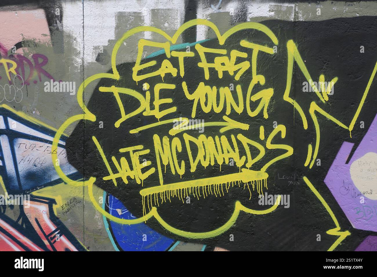 Graffiti FRESSEN SCHNELL, STERBEN JUNG, HASSEN MC DONALD's, besprüht auf einen Überrest der Berliner Mauer in der Mühlenstraße, Berlin, Deutschland, Europa Stockfoto