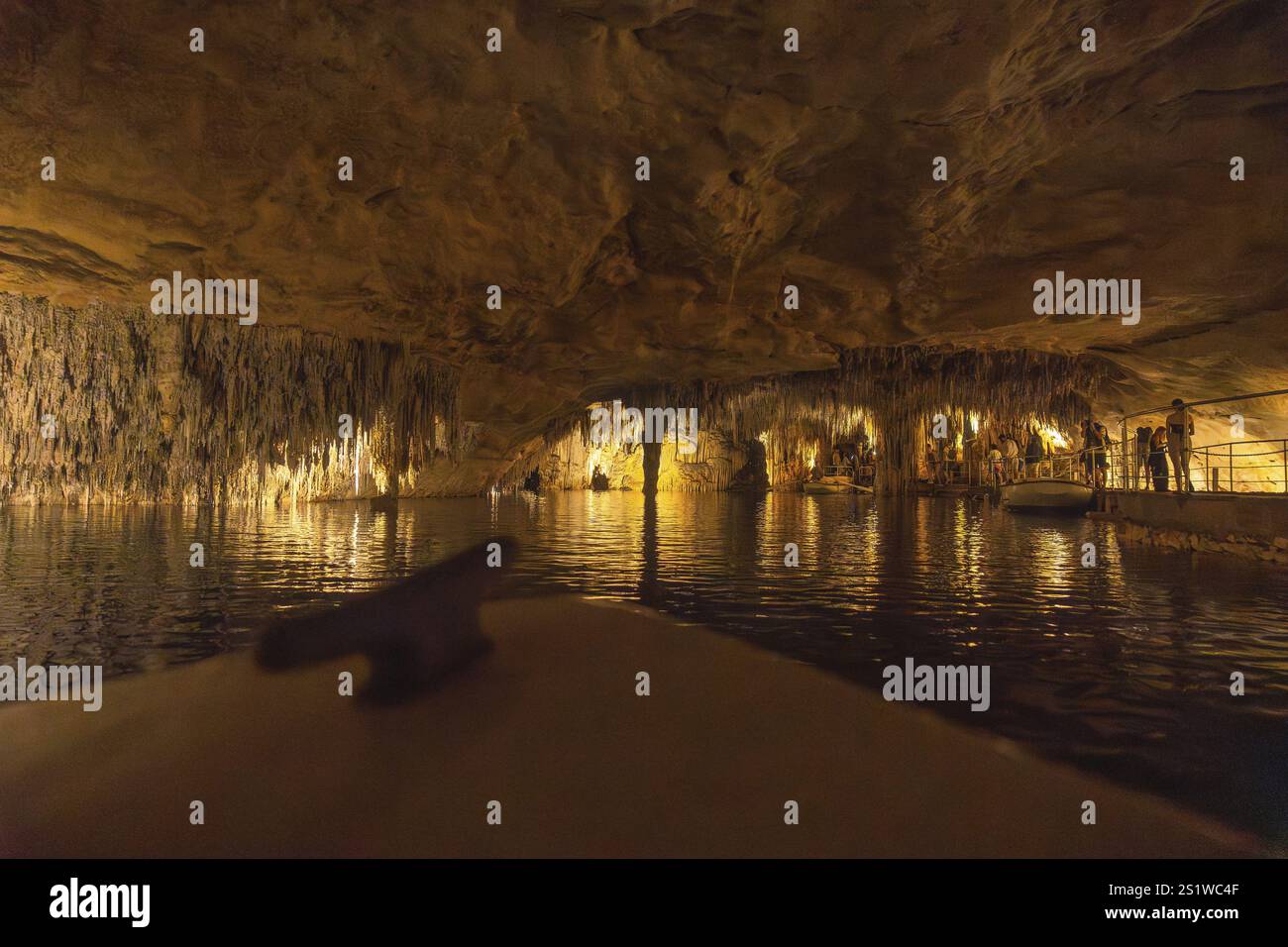 Touristen, die eine Bootsfahrt auf dem martel-See in den Höhlen von drach genießen, beleuchtet von bunten Lichtern, schaffen eine magische und geheimnisvolle Atmosphäre Stockfoto