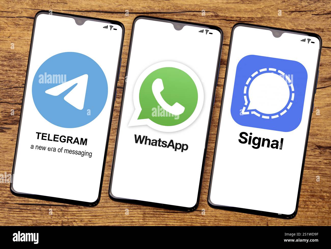 HUETTENBERG, Deutschland 2021-12 14: TELEGRAMM WHATSAPP und SIGNAL App auf einem Handy-Bildschirm. Draufsicht auf hölzernem Hintergrund Stockfoto