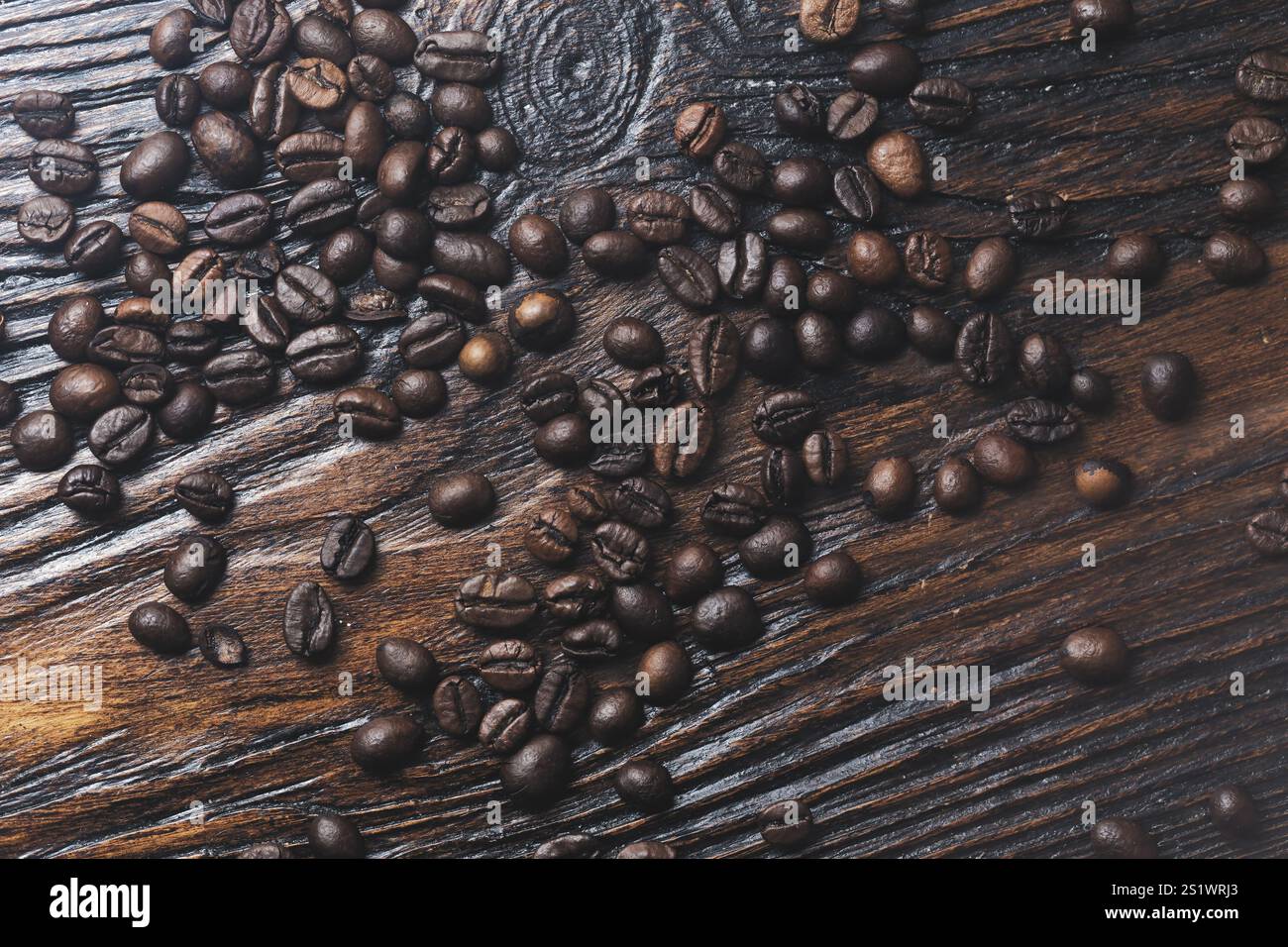 Kaffeebohnen auf dunklem hölzernem Hintergrund Stockfoto