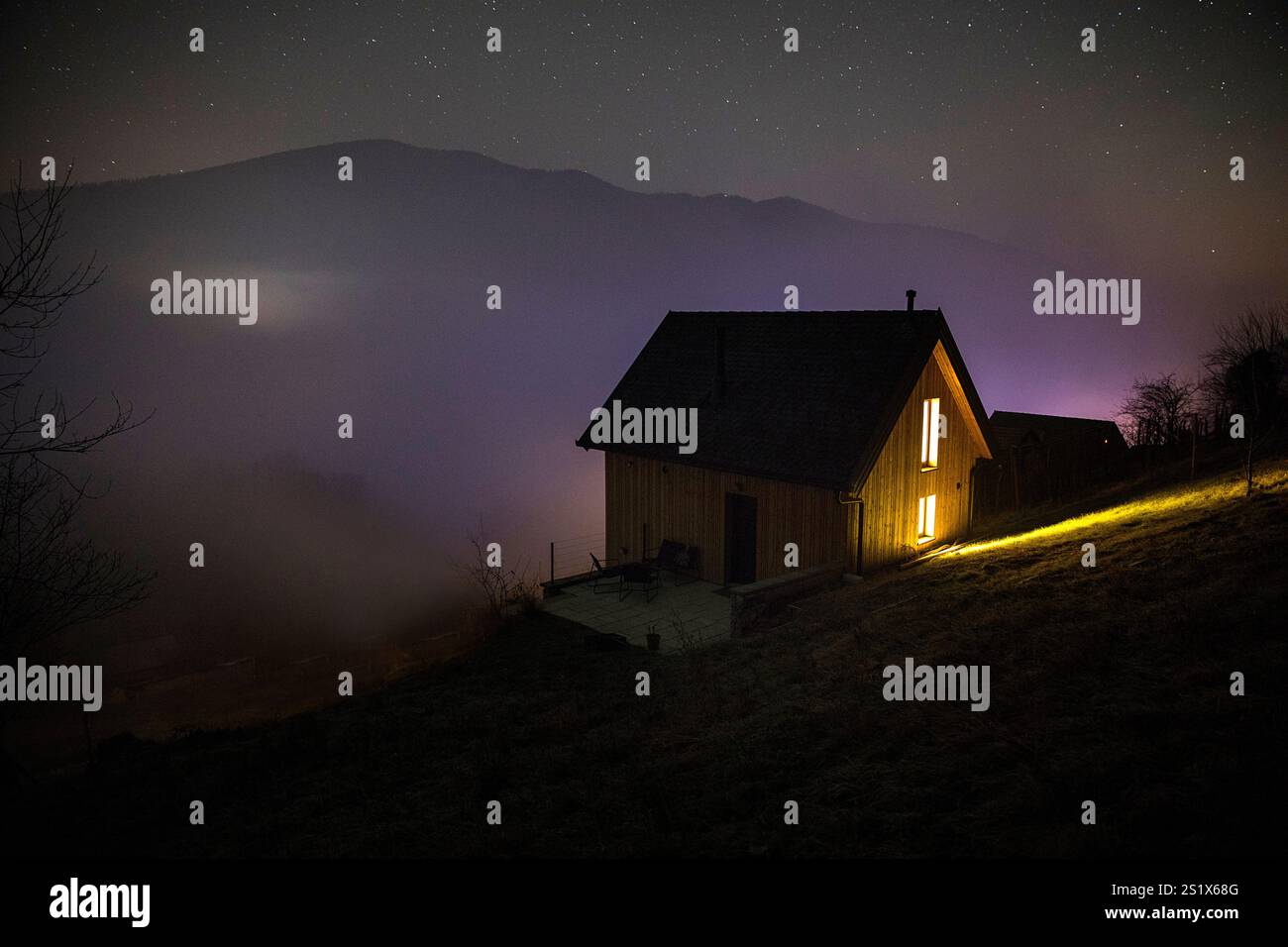 Minimalistisches hölzernes Land, Weinberghütte bei Nacht mit Lichtern in der Nähe des Kurorts dolenjske toplice, umgeben von Weinbergen, Slowenien Stockfoto
