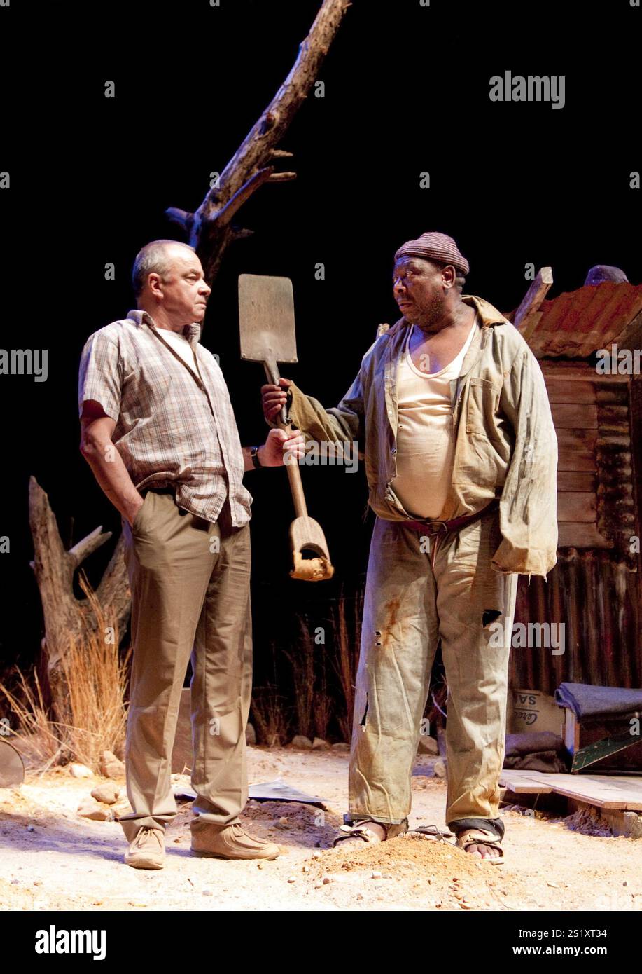 l-r: Sean Taylor (der Zugführer), (in Hütte) Owen Sejake (der Grabgräber) im ZUGFÜHRER geschrieben und inszeniert von Athol Fugard am Hampstead Theatre, London NW3 09/11/2010 A Fugard Theatre Produktionsdesign: Saul Radomsky Beleuchtung: Mannie Manim Stockfoto