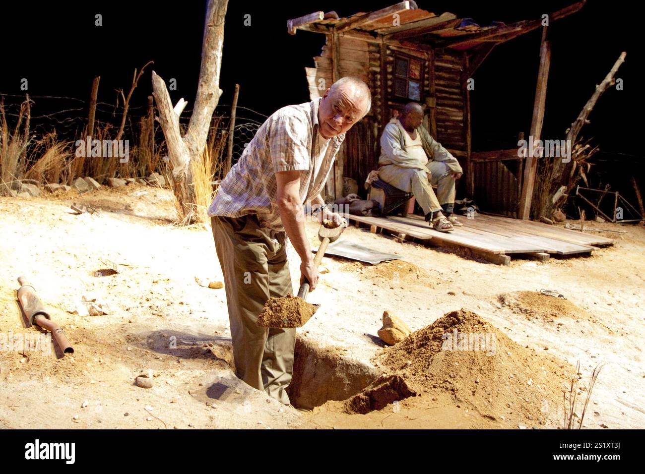 l-r: Sean Taylor (der Zugführer), (in Hütte) Owen Sejake (der Grabgräber) im ZUGFÜHRER geschrieben und inszeniert von Athol Fugard am Hampstead Theatre, London NW3 09/11/2010 A Fugard Theatre Produktionsdesign: Saul Radomsky Beleuchtung: Mannie Manim Stockfoto